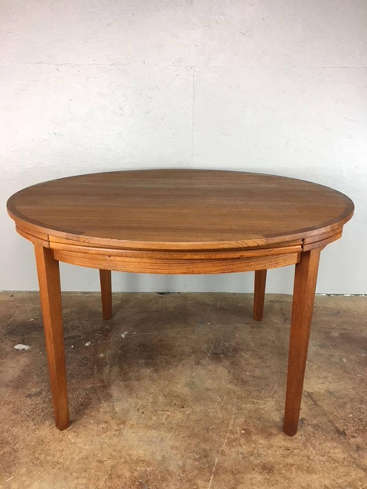 Uniquely designed round 47 inch teak dining table by Dyrlund. Under mounted 11 inch extensions pull-out and flip over, extending table from 47 round to 69 inches round.

Condition: Excellent original condition. 