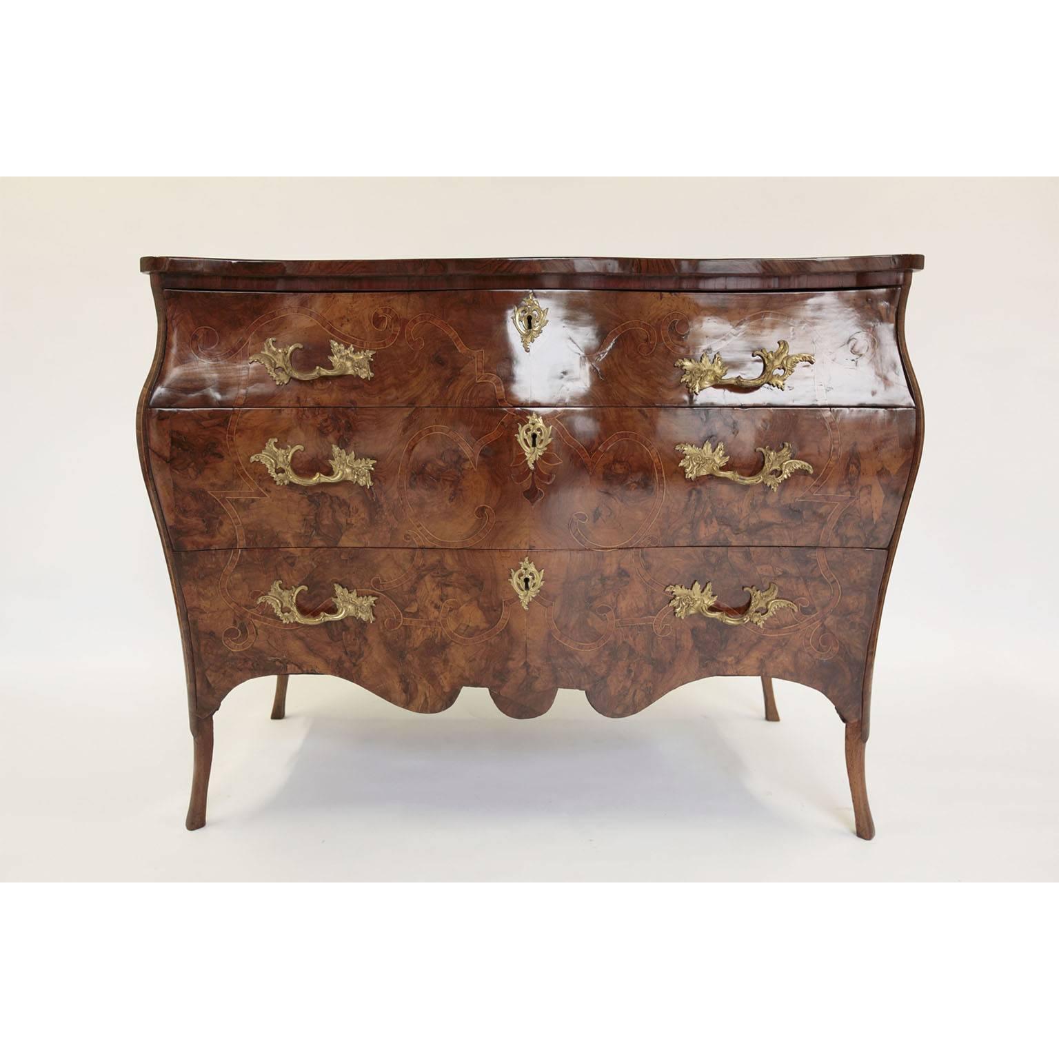 18th century Italian commode with a bombe' shape on front and sides.
Walnut burl veneer on front and side with elegant ornamental marquetry.
The decoration on the top is made with walnut veneer that joins in the centre and framed by an