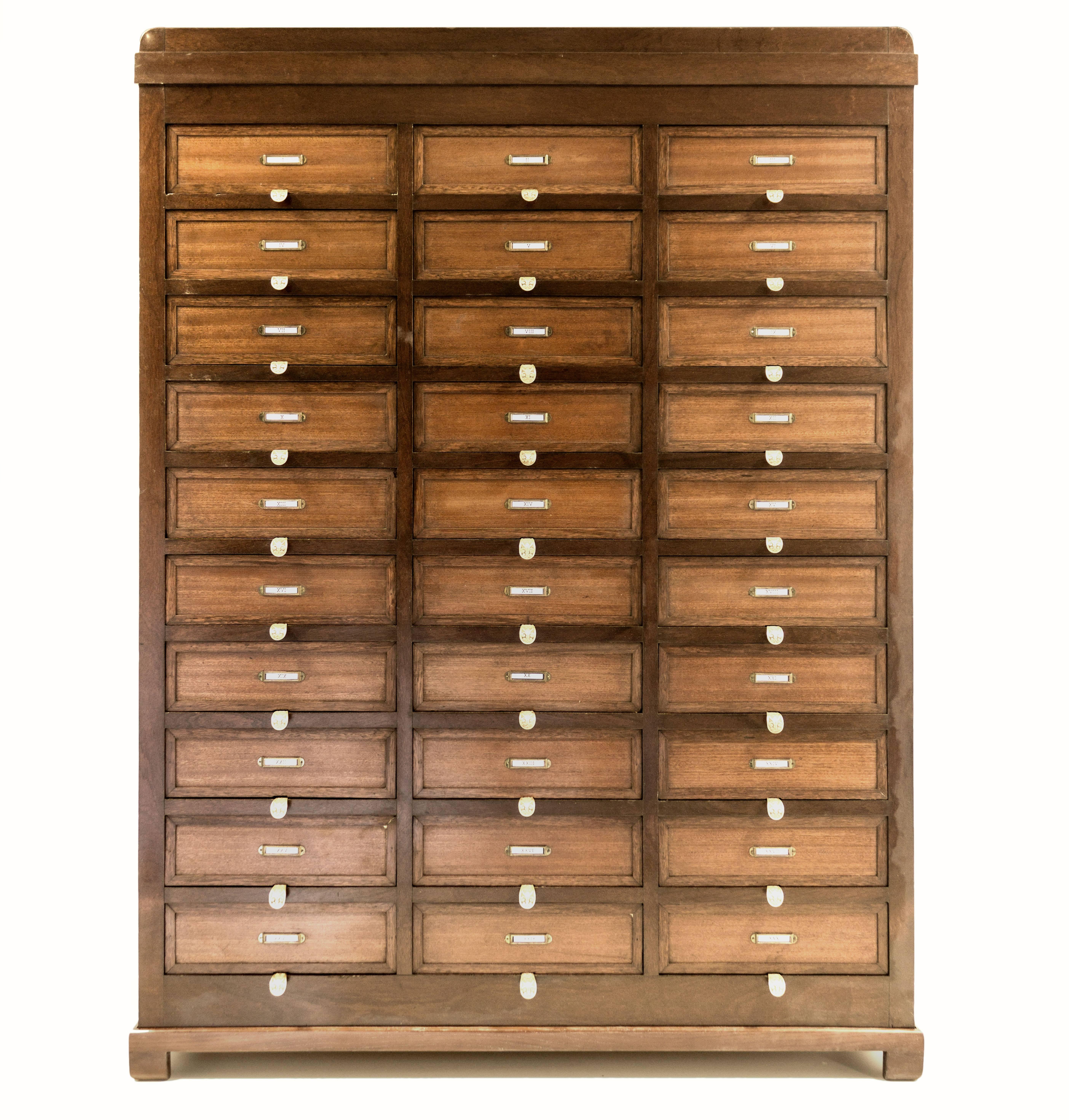 Mid-20th century mahogany filling cabinet.
The cabinet has 30 drawers with a functional pull over system.
Each drawer has a beautiful solid brass rod to pull it over.
The base has been added in a second time and it is not authentic as the rest of