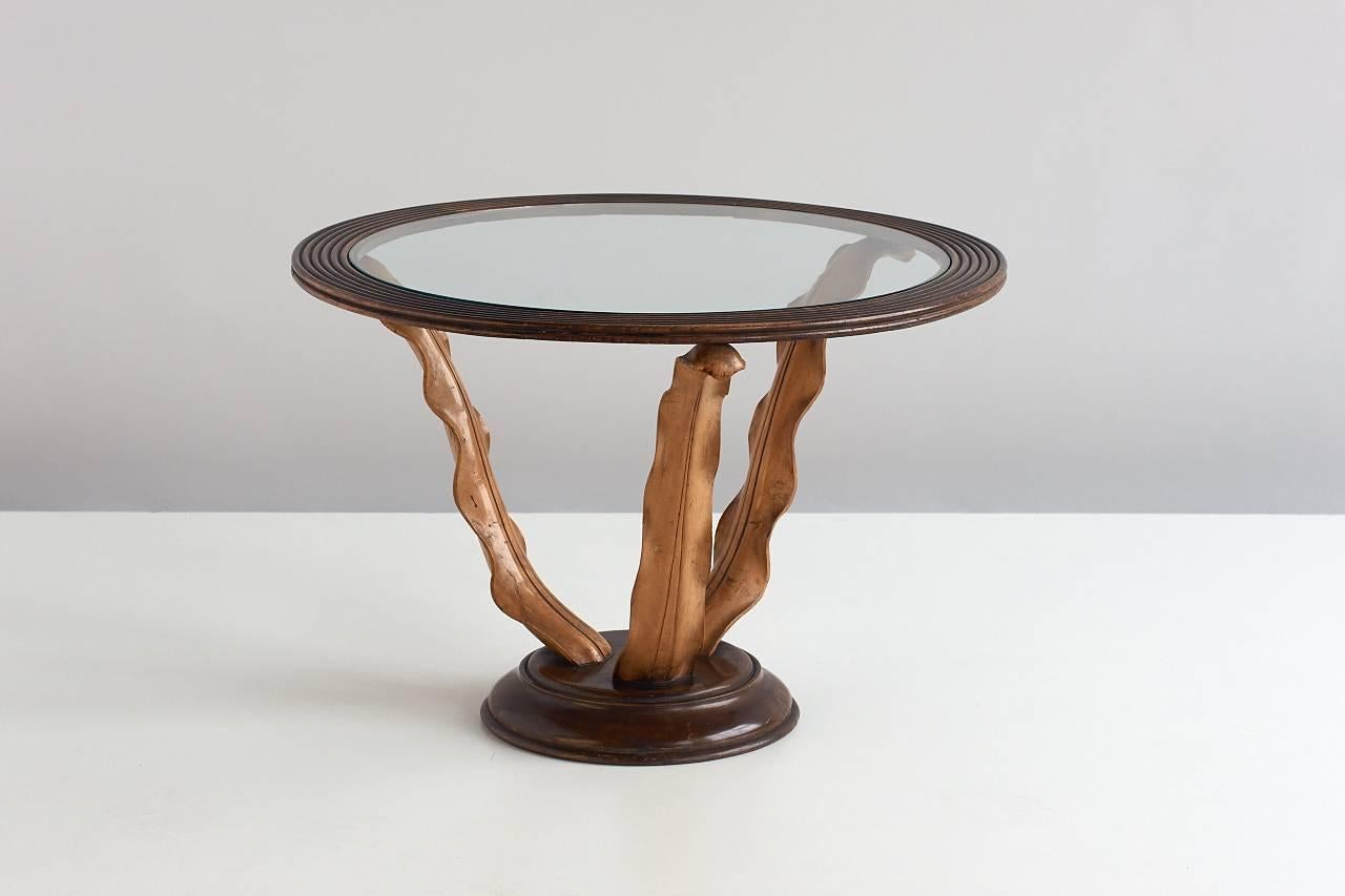 A classic and refined side table designed by Paolo Buffa. The glass top is supported by a circular wood frame, which stands on three beautifully hand carved wooden leaves. This rare design is a stunning example of Buffa’s craftsmanship and of the