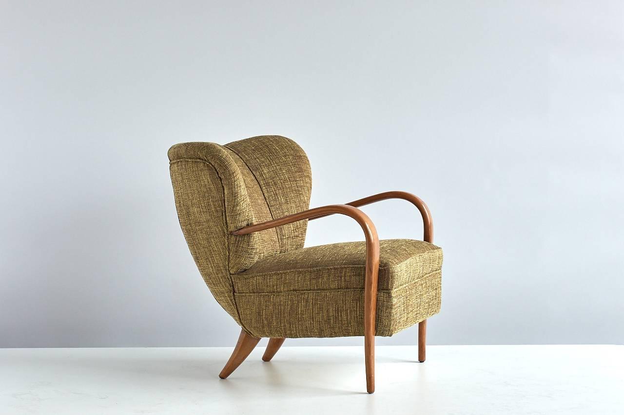 An important pair of 1940s armchairs designed by Silvio Cavatorta. These chairs were made by hand in the Cavatorta workplace in Rome, known for its meticulous artisanal production methods. The walnut arms of the chair bend around to form the chair’s