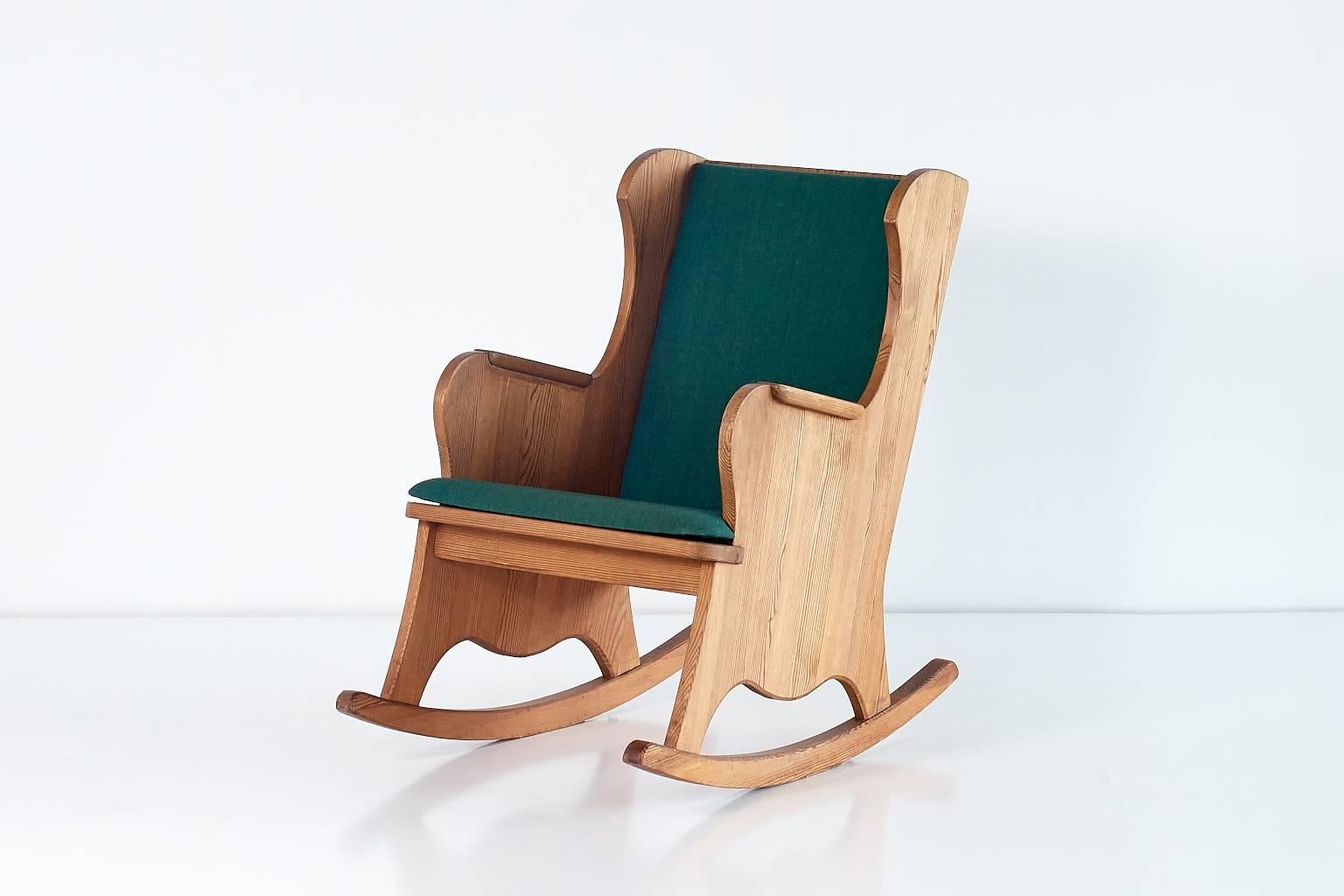 This rare rocking chair is part of the 'Lovö' series designed by Axel Einar Hjorth for the high-end Stockholm-based Nordiska Kompaniet department store in 1932. Executed in pinewood, this chair offers a particularly striking woodgrain. The original