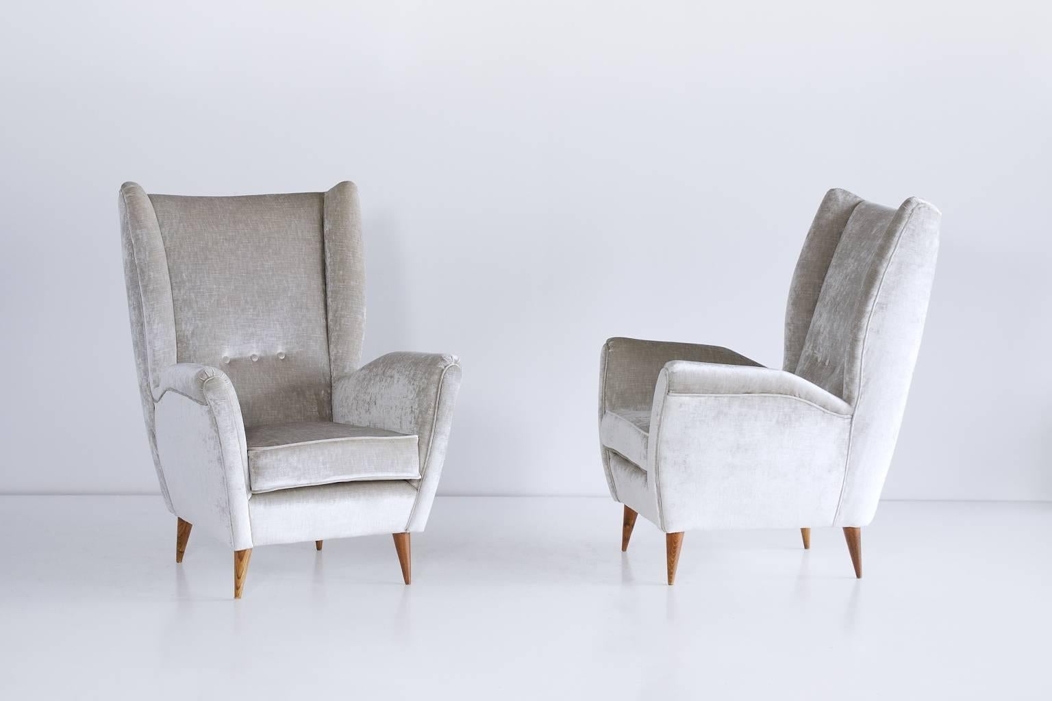 These high back armchairs were designed by Gio Ponti in the late 1940s. The chairs are characterized by their strikingly modern lines, elegantly tapered walnut legs and generous proportions.
The comfortable armchairs have been fully reconditioned