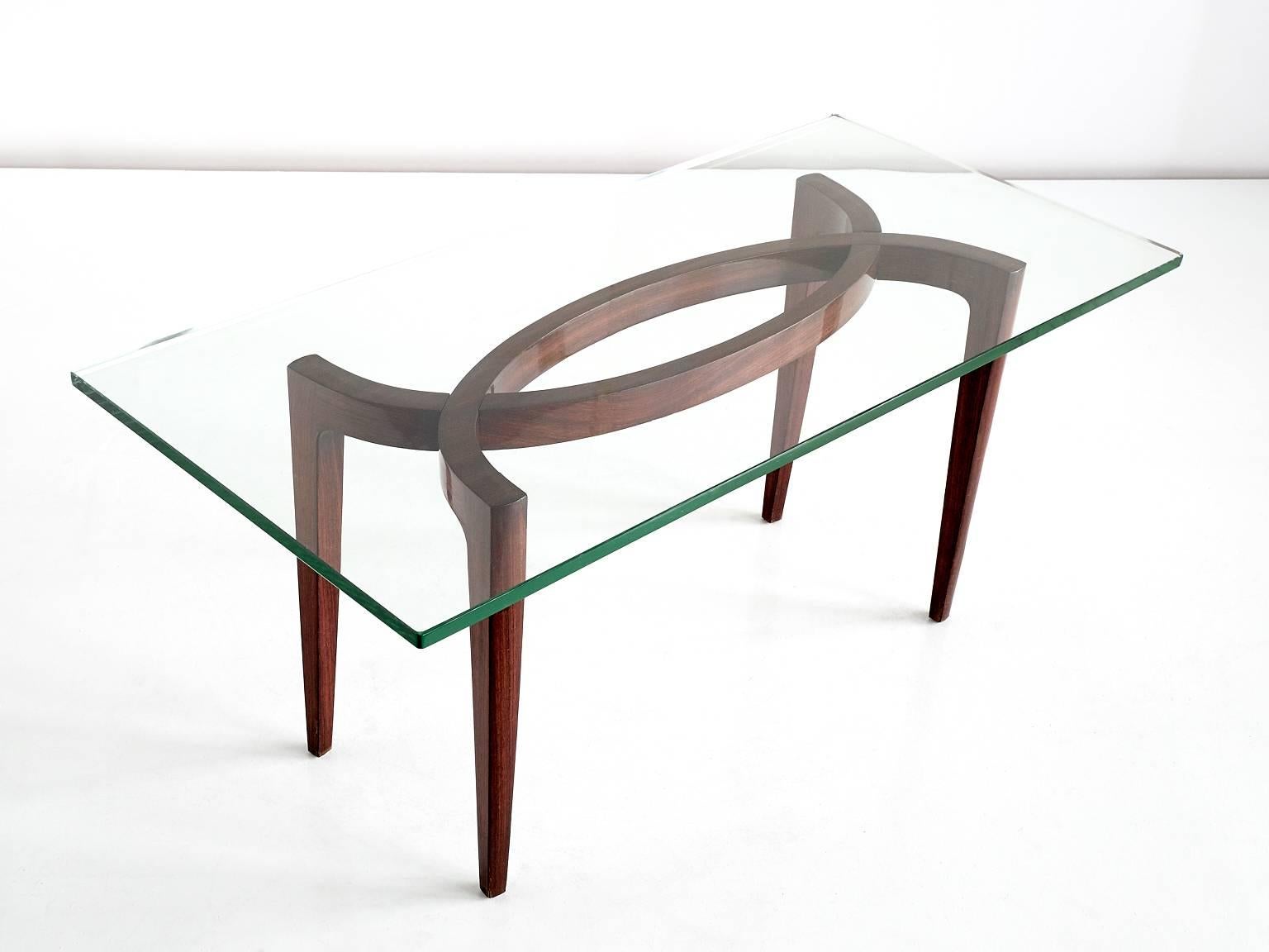 This rare rectangular table was designed by Carlo Enrico Rava in the late 1940s. The Italian glass top is resting on a rosewood-veneered frame. The sculptural shape of the frame makes this a striking and elegant design.
Due to its dimensions, the