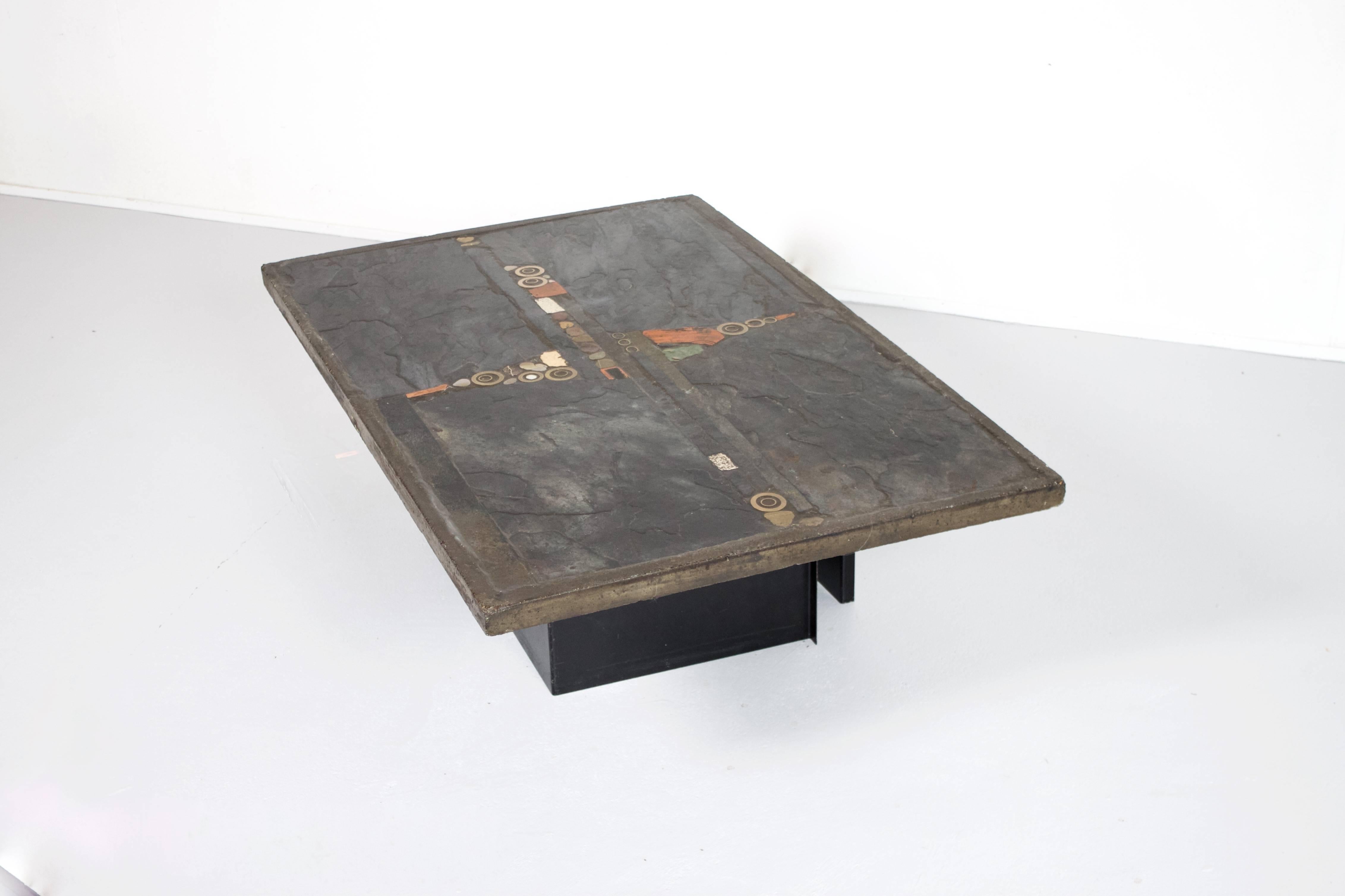 Unique Brutalist coffee table by the Dutch sculptor Paul Kingma.

The tabletop is a mosaic of slate panels, colored stones and brass details.

The table is signed by the artist in a brass ring inserted into the tabletop.

The base consists of