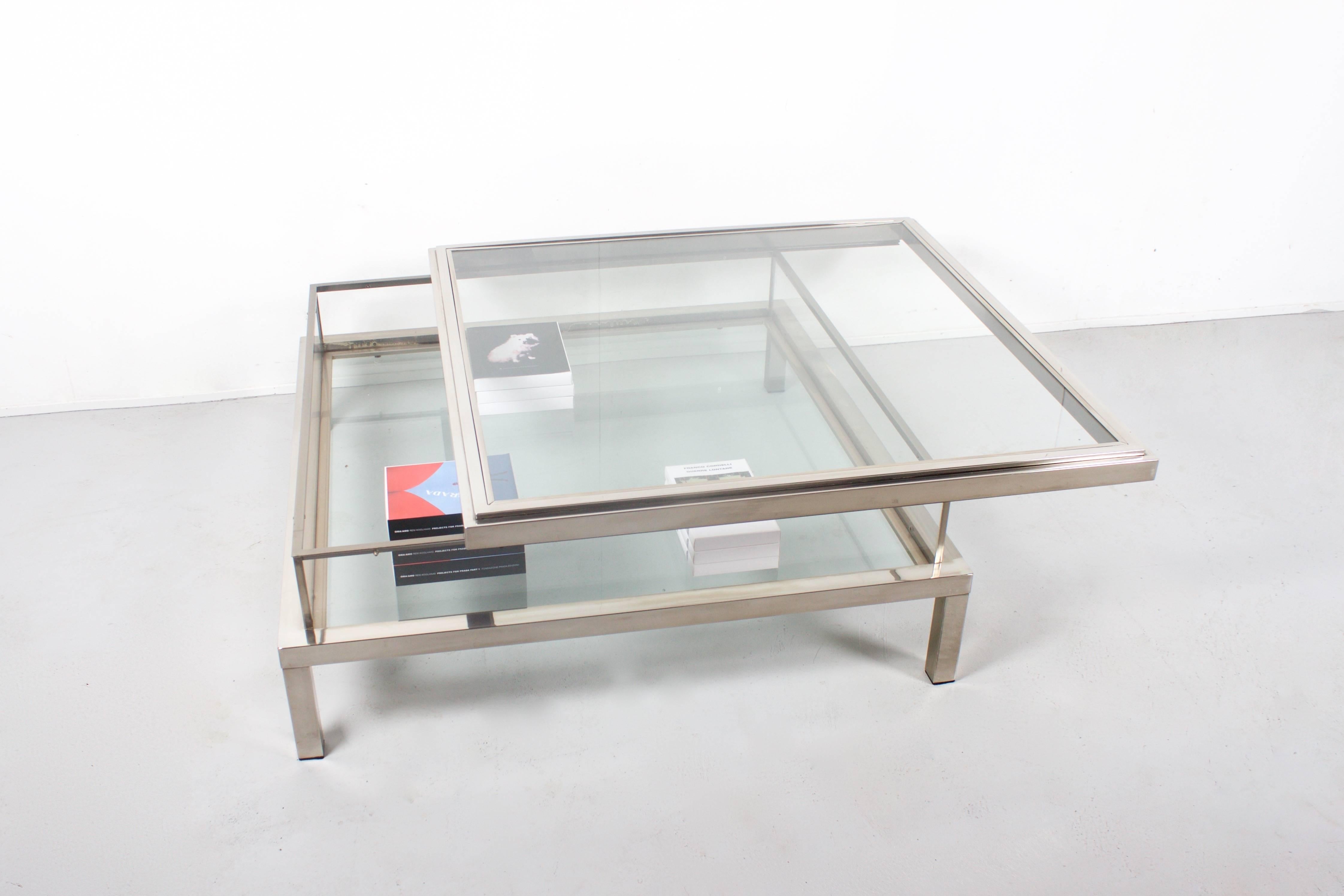 1970s coffee table by Maison Jansen in very good condition.

Satined chrome with glass tops and Lucite walls.

The top can slide open to reveal the inside compartment that can be used as a vitrine for books and magazines.

This table is very