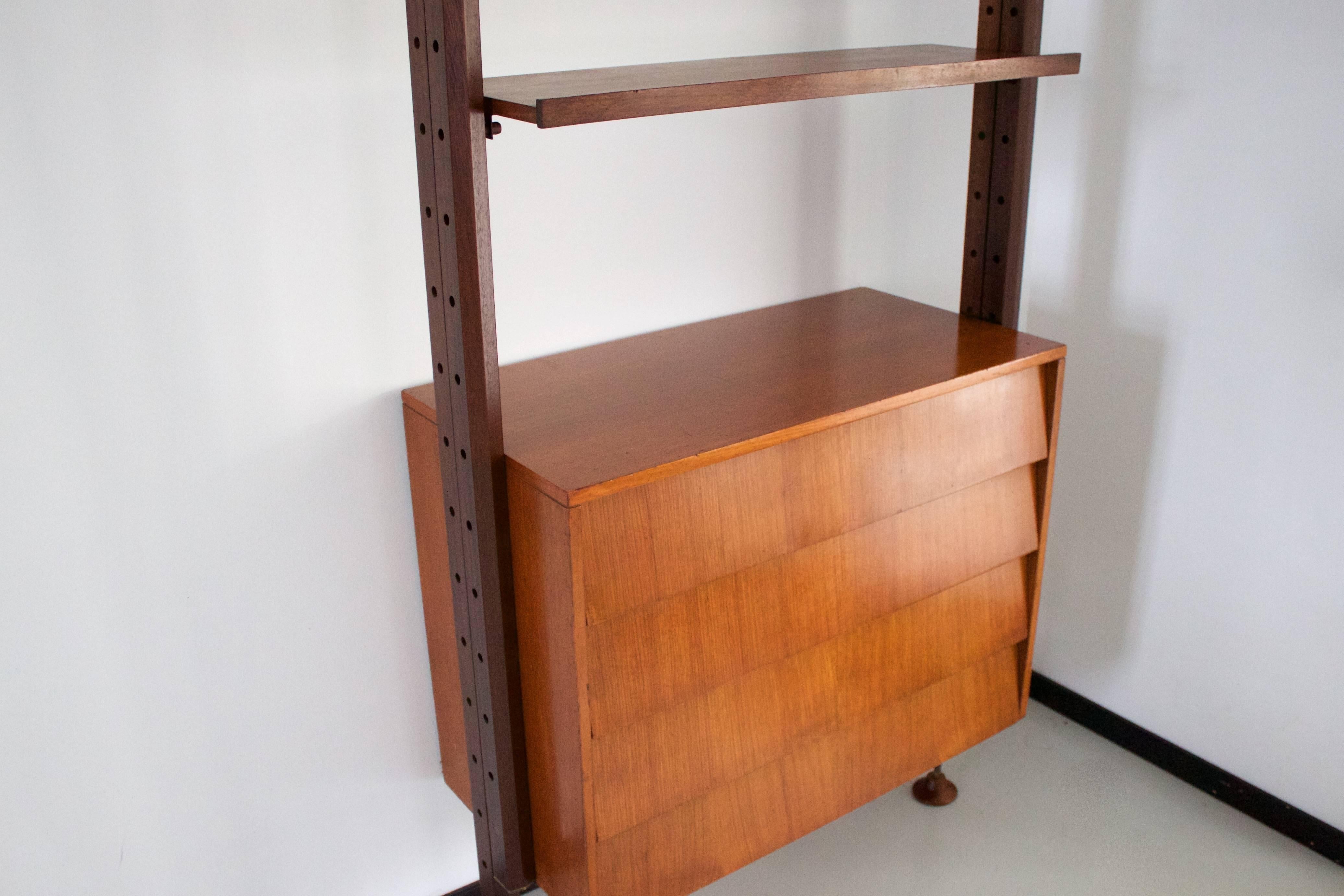 Impressive wooden ISA wall unit in very good condition.

It consists of four teak shelves, a cheerywood chest of drawers and two teak stands. 

The solid teak stands are adjustable in height up til 440 cm. (173 Inch) 

The unit comes with four