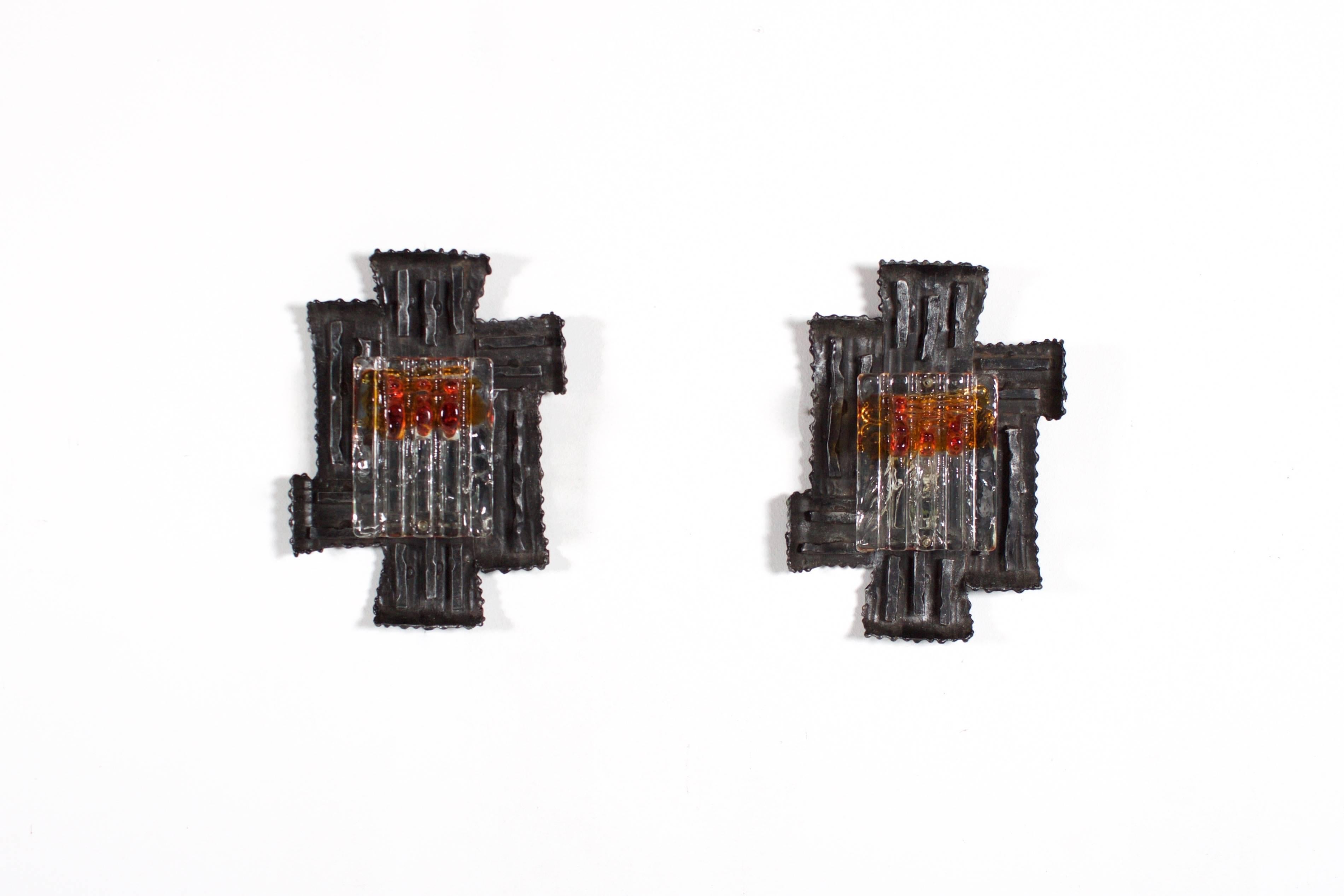 Merveilleuse paire d'appliques suédoises brutalistes de Tom Ahlström et Hans Ehrich.

Fabriqué par A & E Leuchten.

Un cadre en fer forgé à la main contient un verre à glace de Murano ambré et transparent.

Le verre ambré et transparent donne