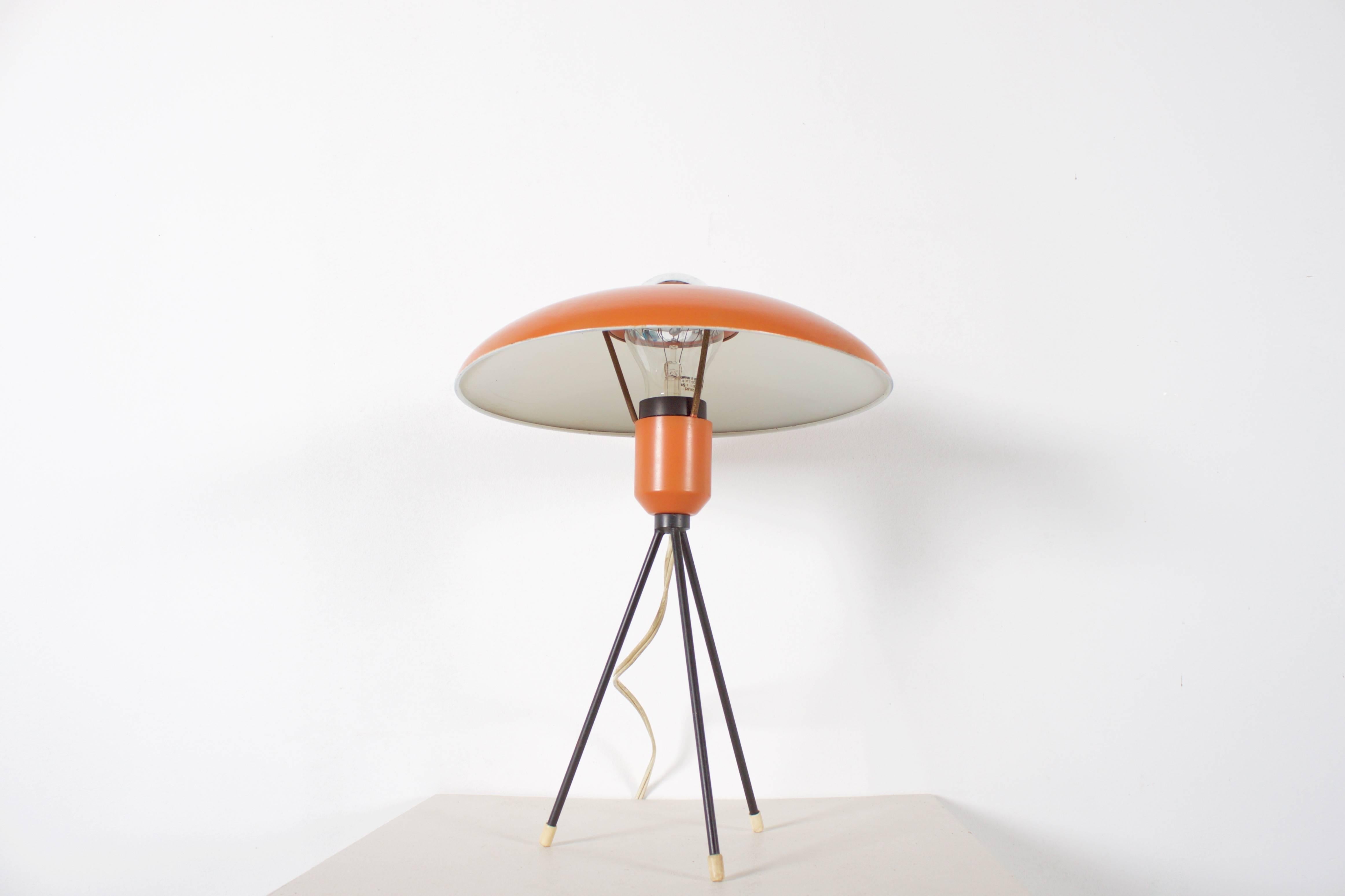Very rare Louis Kalff tripod table lamp.

Manufacturer: Philips.

Shade lacquered in orange, tripod lacquered black.

White rubber feet.

The lamp has bin rewired.

If you have any questions, please feel free to contact us.

In the style