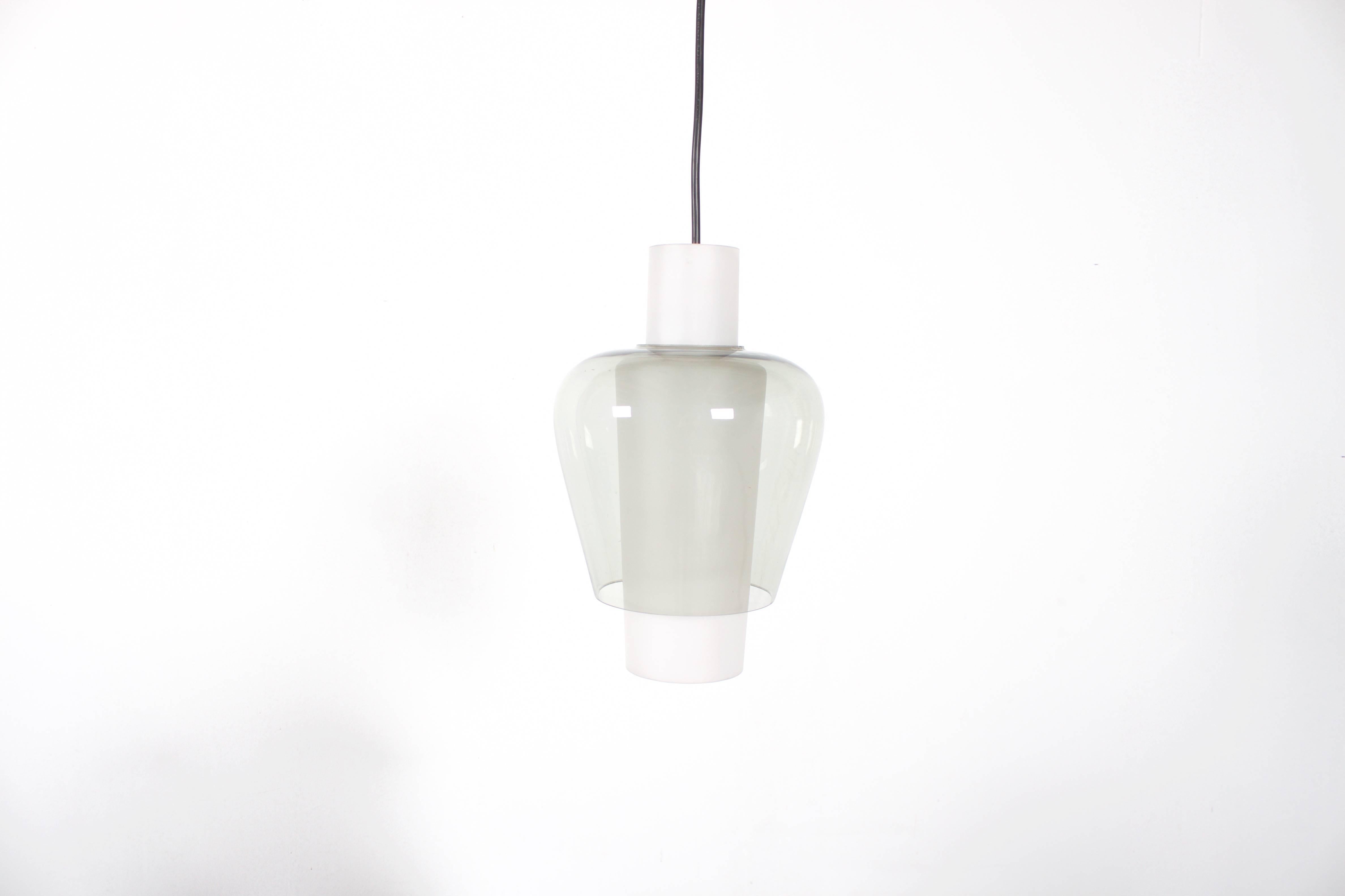 Set of Tapio Wirkkala ‘Suomi’ pendants in very good condition.

Handblown glass.

Made of two pieces, an opaline inner shade which is covered with a transparent grey colored glass shade.

Rewired.

One bulb E27 socket, max. 100 watt - 110/220