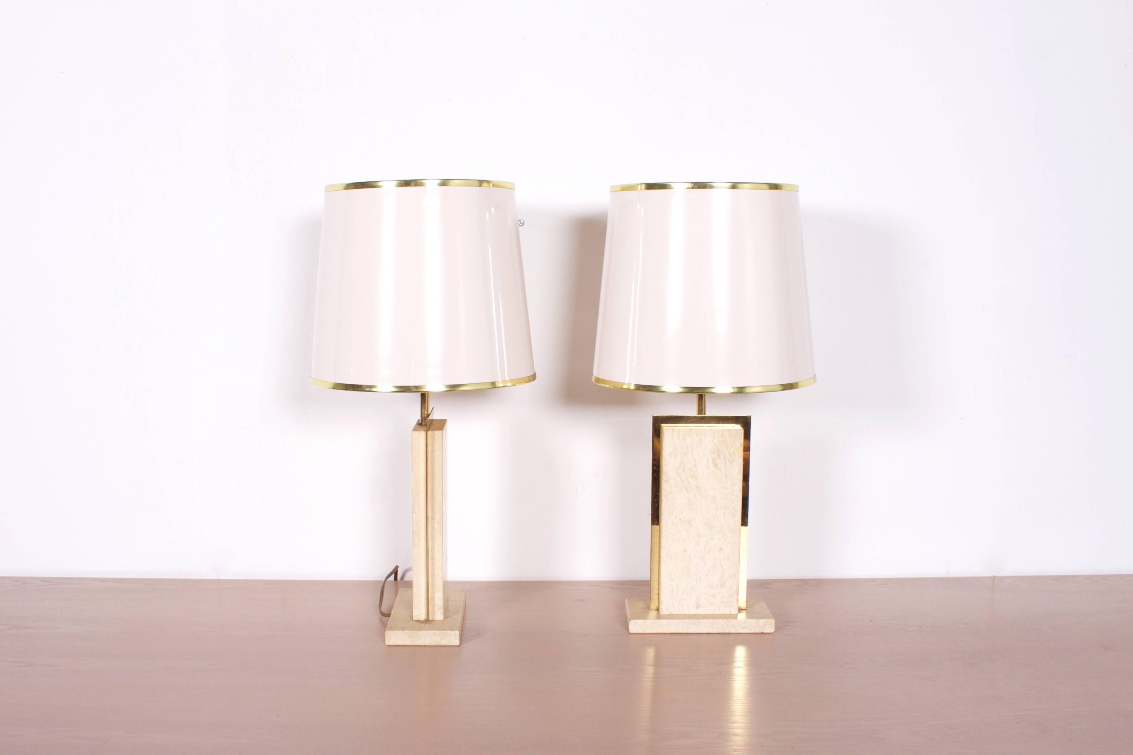 Two compact Willy Rizzo table lamps in good condition.

Manufacturer: Stone International.

Made of travertine with brass details.

White shade with a gold colored inside.

