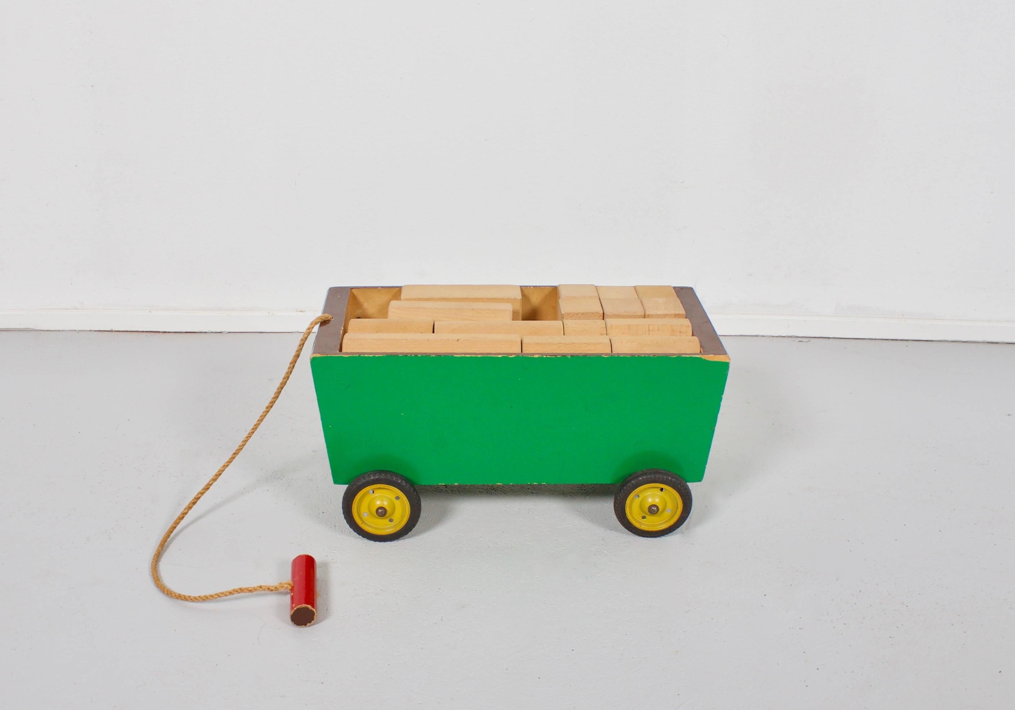 Wooden Ko Verzuu Toy Cart in beautiful original condition.

Manufactured by Ado Holland (Arbeid door onvolwaardigen) founded in 1925.

This Cart stil has the original paint, wheels and rubber tires.
It can be pulled by a rope with a wooden