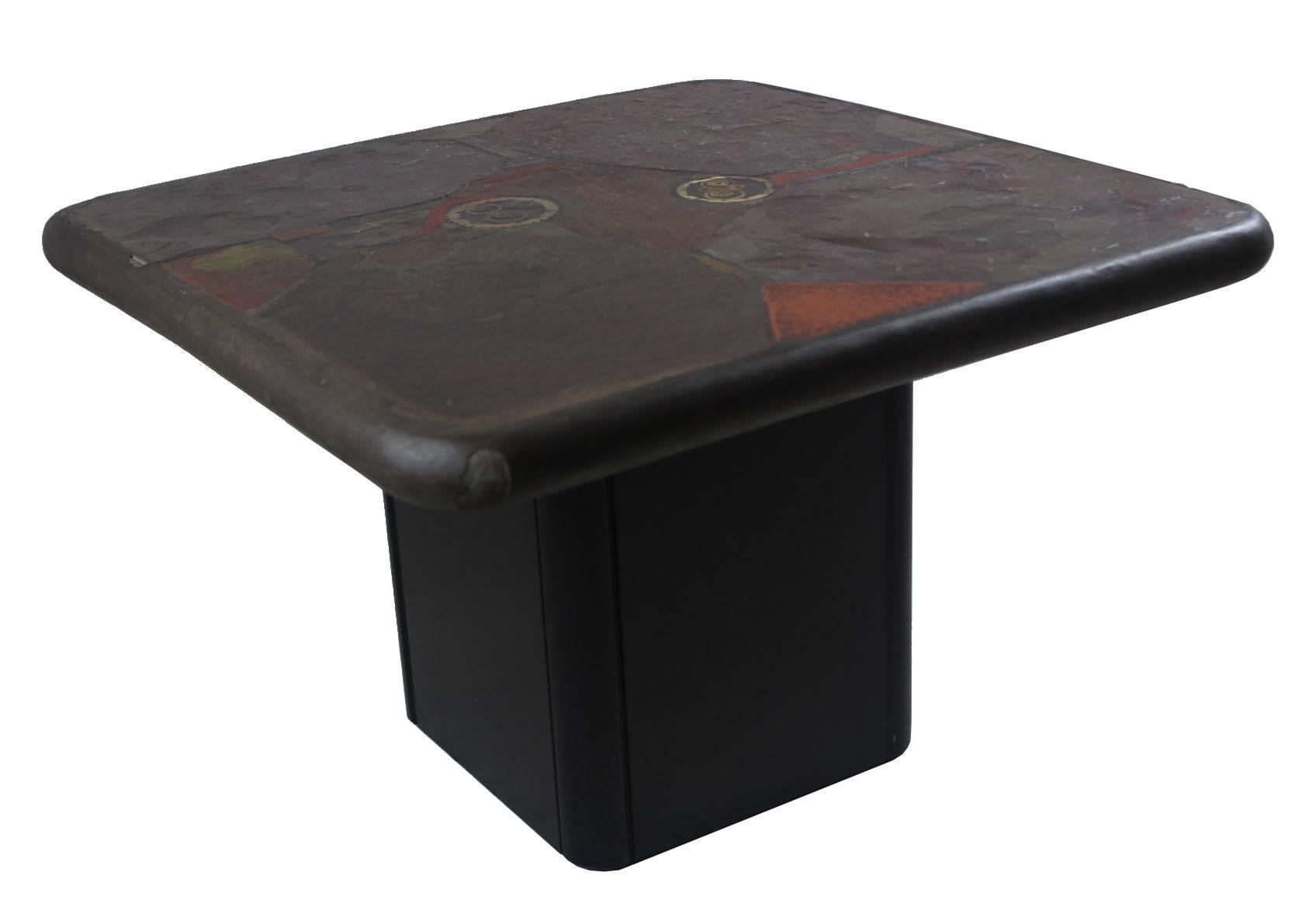 Coffee table labeled by Kneip 89. The base is made from blackened wood, the top is made from slate with brass details.