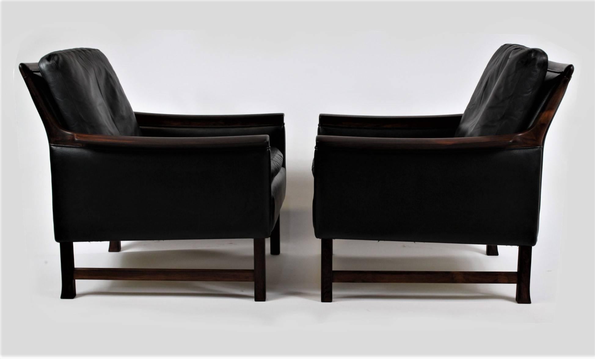 Pair of high quality black leather club chairs Minerva, designed by Norwegian designer Torbjørn Afdal for Bruksbo. Material is rosewood and perfectly worn leather. The chairs are in excellent vintage condition.