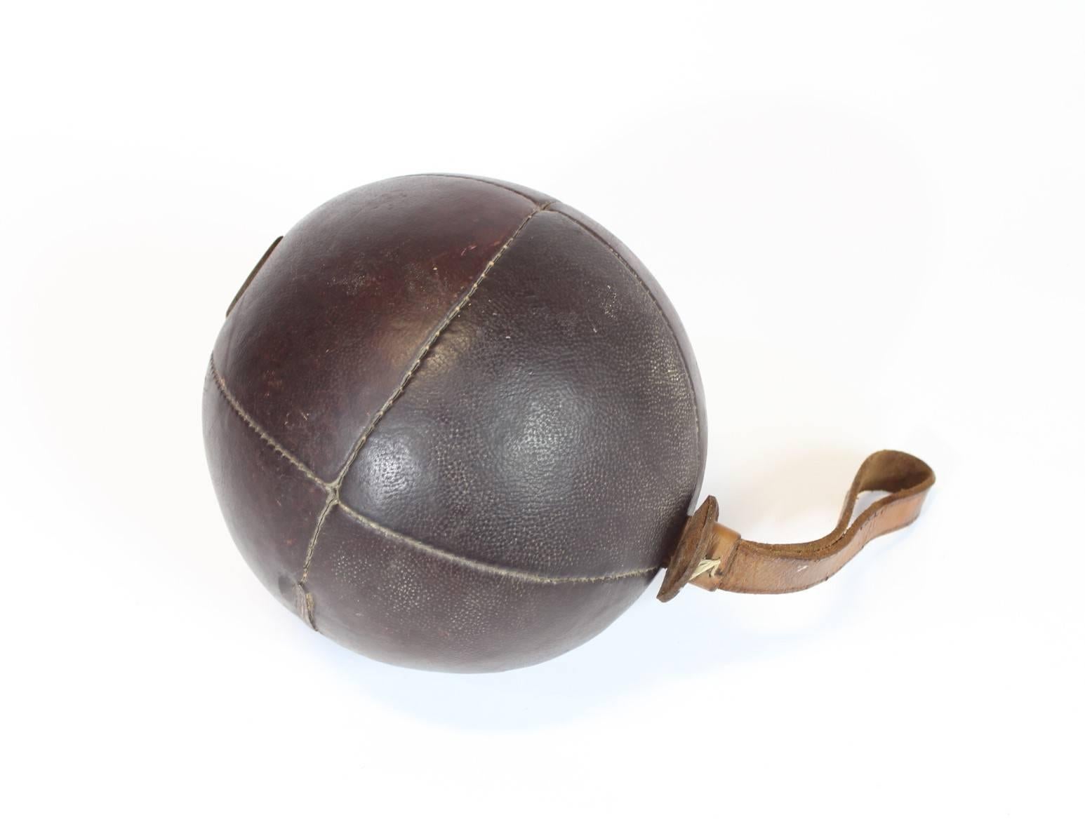 Vintage leather medicine ball with strap from the 1920s.