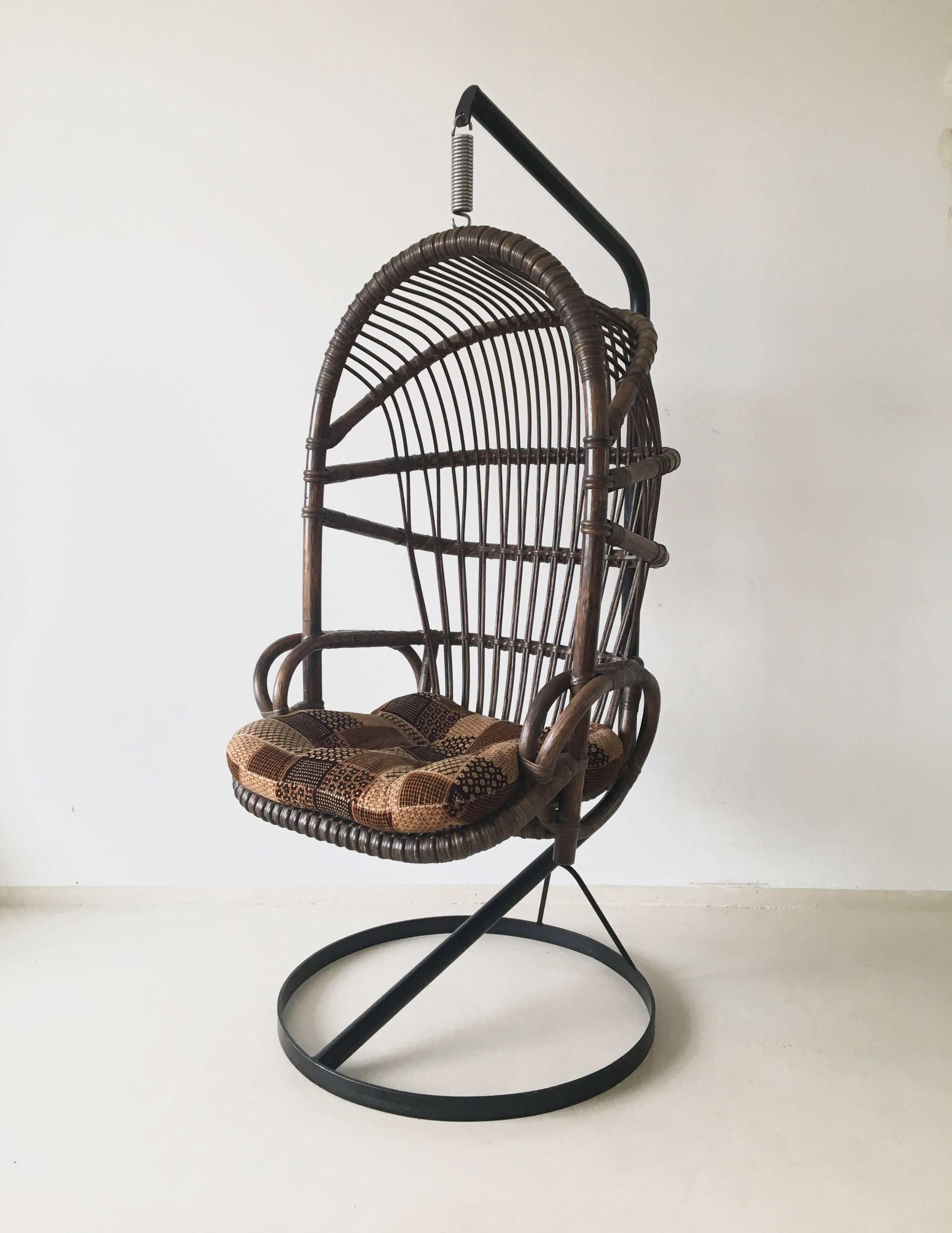 This bamboo and cane hanging chair is a famous 1960s design from The Netherlands. It has a solid metal frame and has it's original color and cushion. It was manufactured by Rohé Noordwolde and remains in a very good vintage condition.