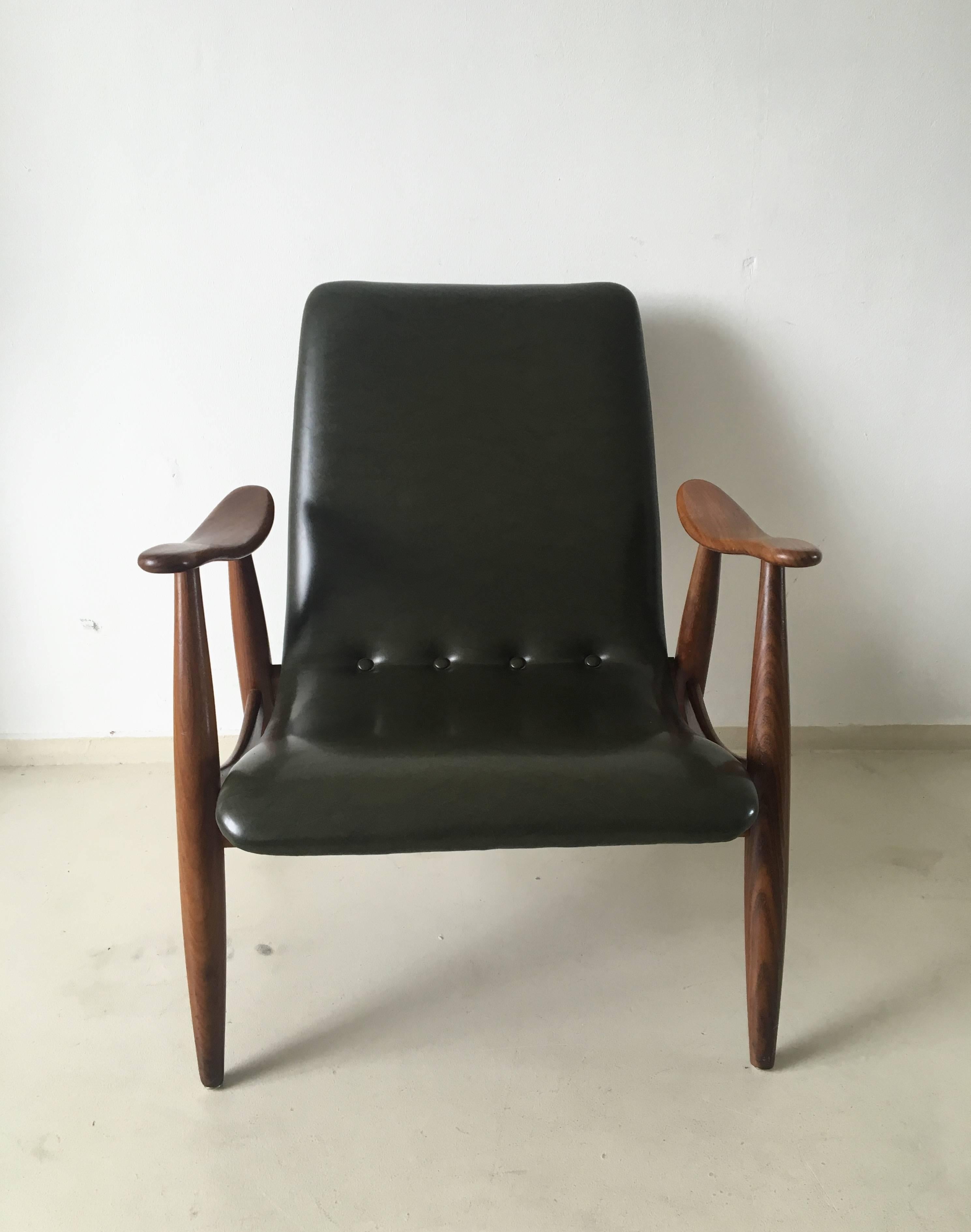 This lounge chair comes with a beautiful organic shaped teak frame, with the original deep green leatherette upholstery. This chair remains in very good condition with minor signs of wear.