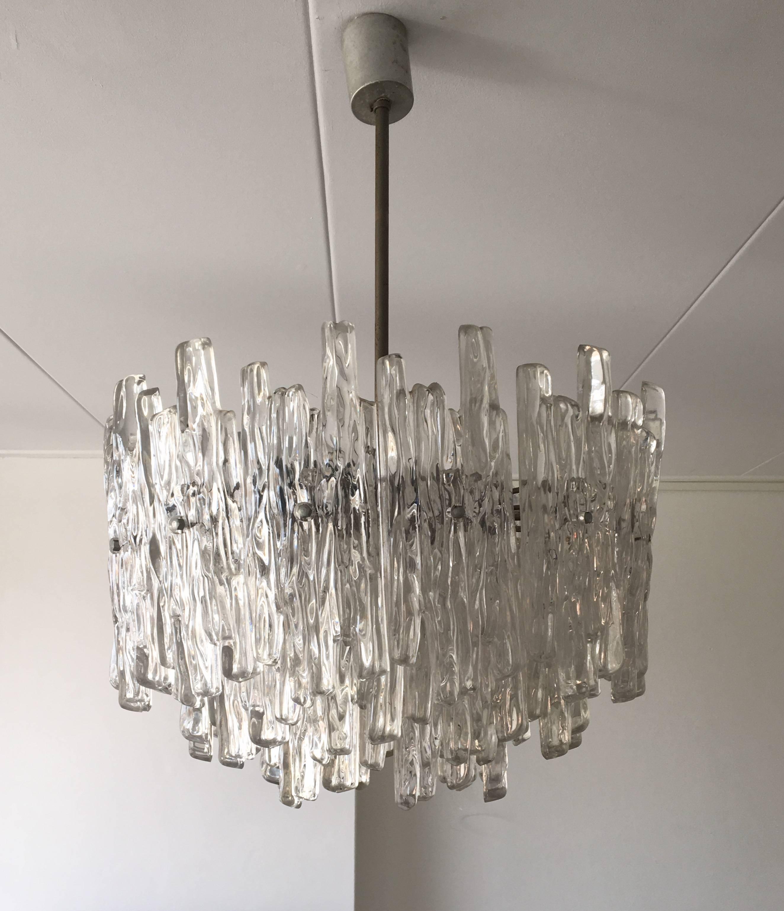 This chandelier was designed and manufactured in Austria, circa the 1960s. It has Lucite iceglass pieces and was created with five light bulbs. It is in a very good condition with some patina on it's metal frame.
 