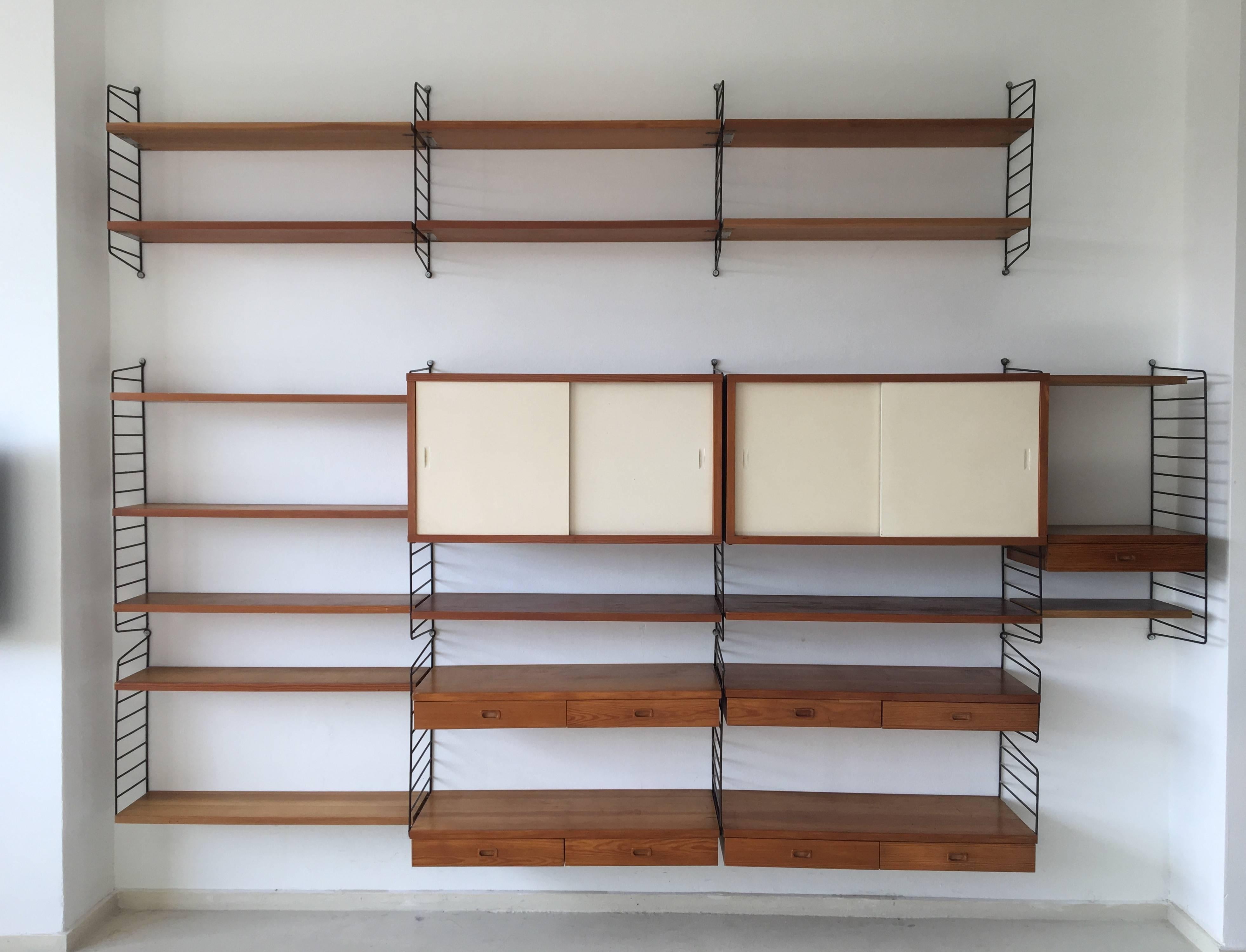 This exceptional three section shelving system was manufactured in pinewood, circa the 1960s By String Design AB in Sweden. Design: Nils Nisse Strinning. It remains in a good vintage condition with wear consistent with age and use. The brackets were