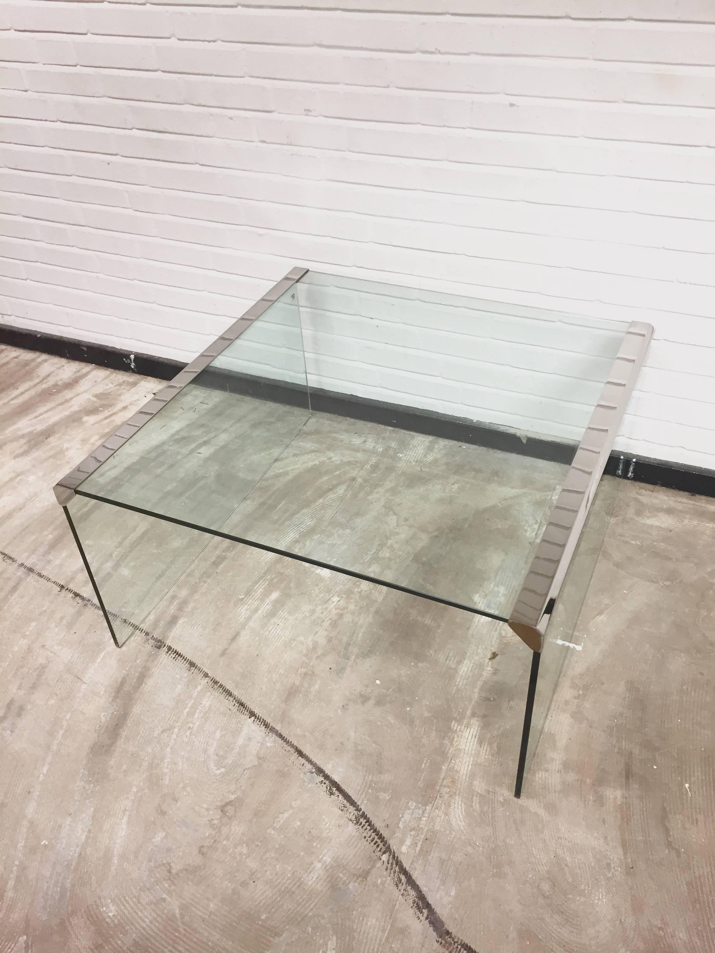 Dieser Couchtisch, Modell T33, wurde von Pierangelo Gallotti für seine Firma Gallotti & Radice im Jahr 1982 entworfen. Er verfügt über eine dicke Platte aus gehärtetem, transparentem Glas mit Kanten aus Edelstahl. Der Tisch ist in einem guten