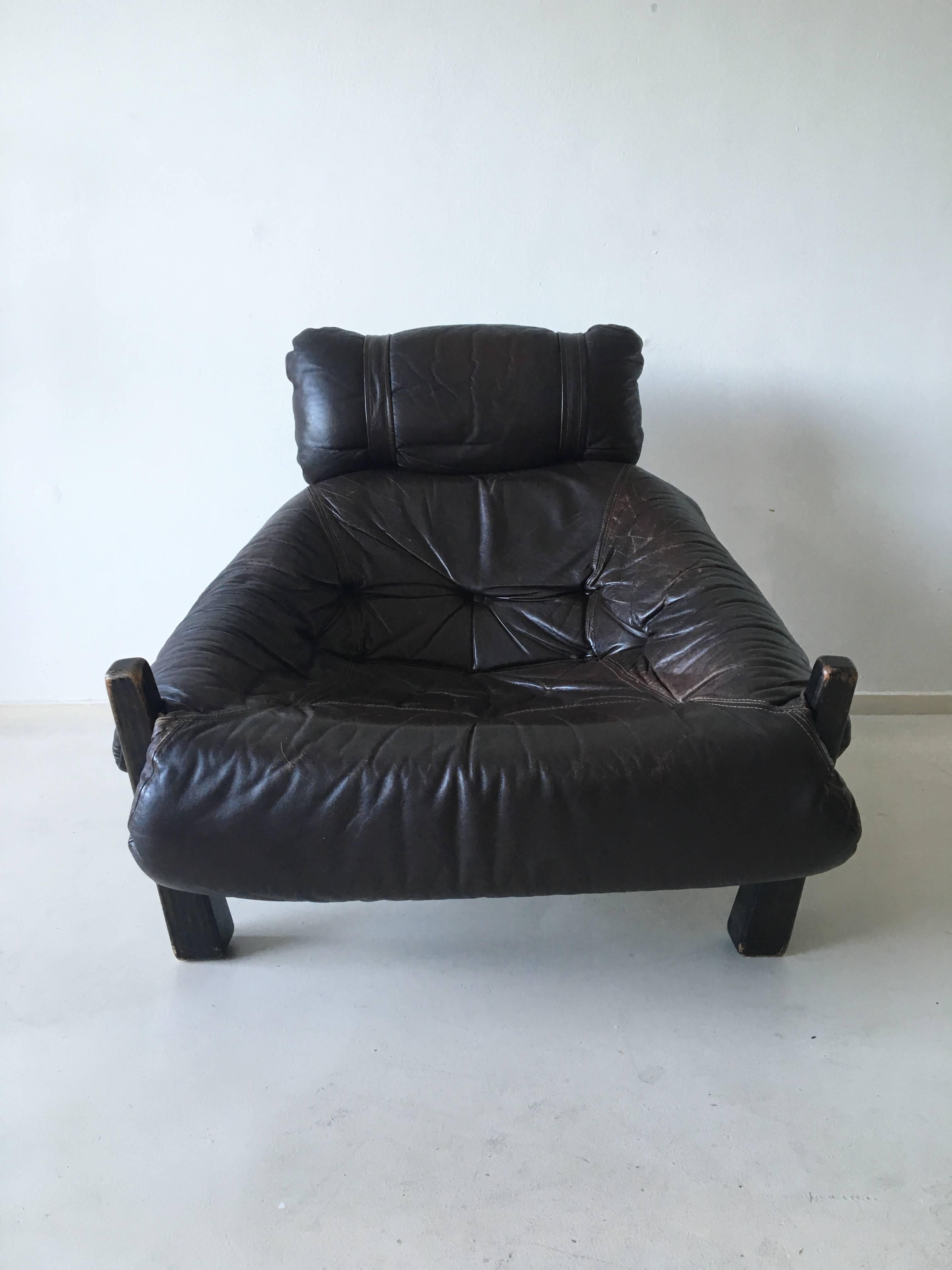 Comfortable lounge chair in style of Percival Lafer. This gorgeous design consists of a brown lacquered wooden frame and leather and fabric upholstery. Some signs of age and use. A few buttons missing. 