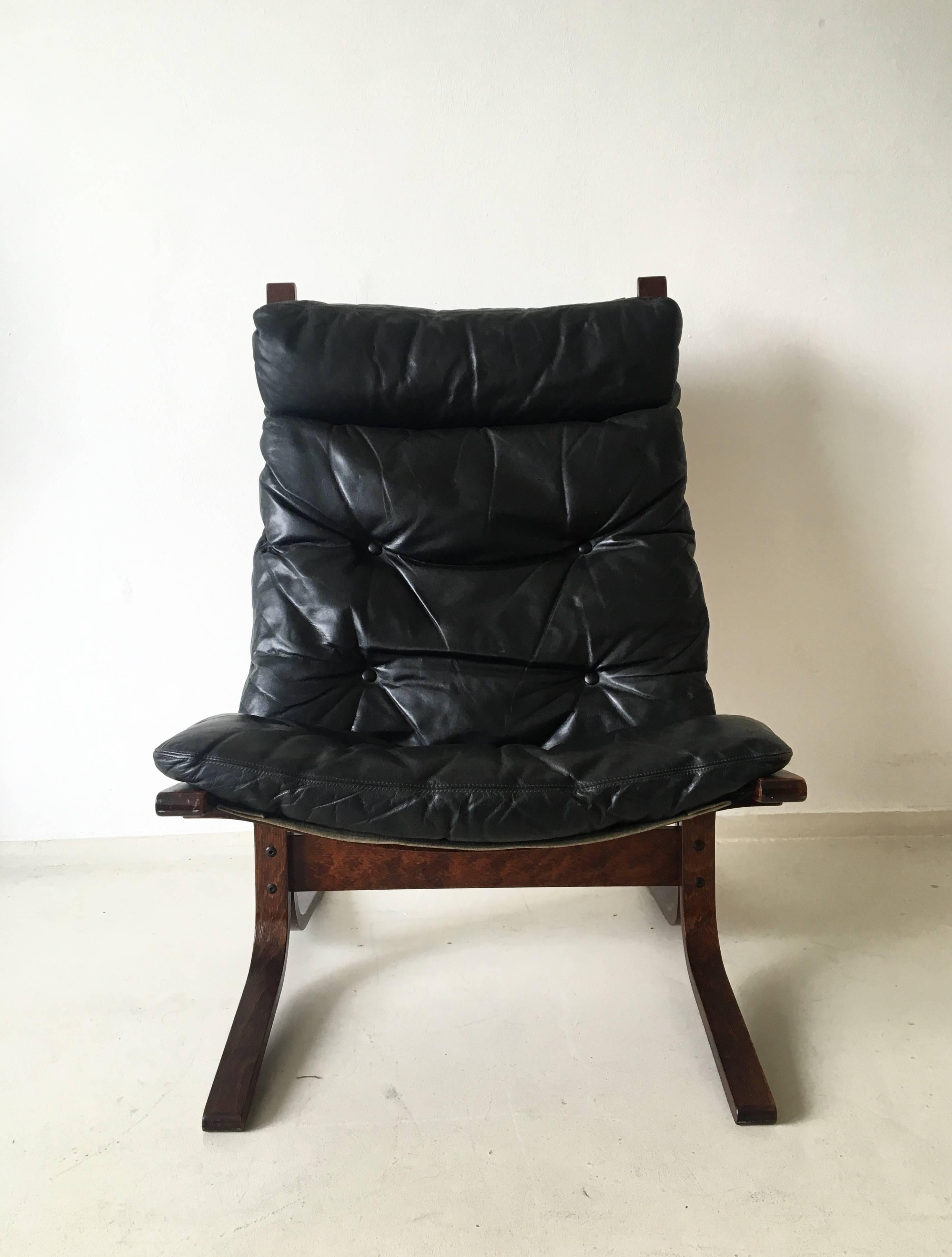 This magnificent chair and ottoman were designed by Ingmar Relling, circa the 1960s in Norway. They feature a dark bentwood frame with very thick and comfortable black leather cushions. Both products are labeled with the manufacturers sticker. The