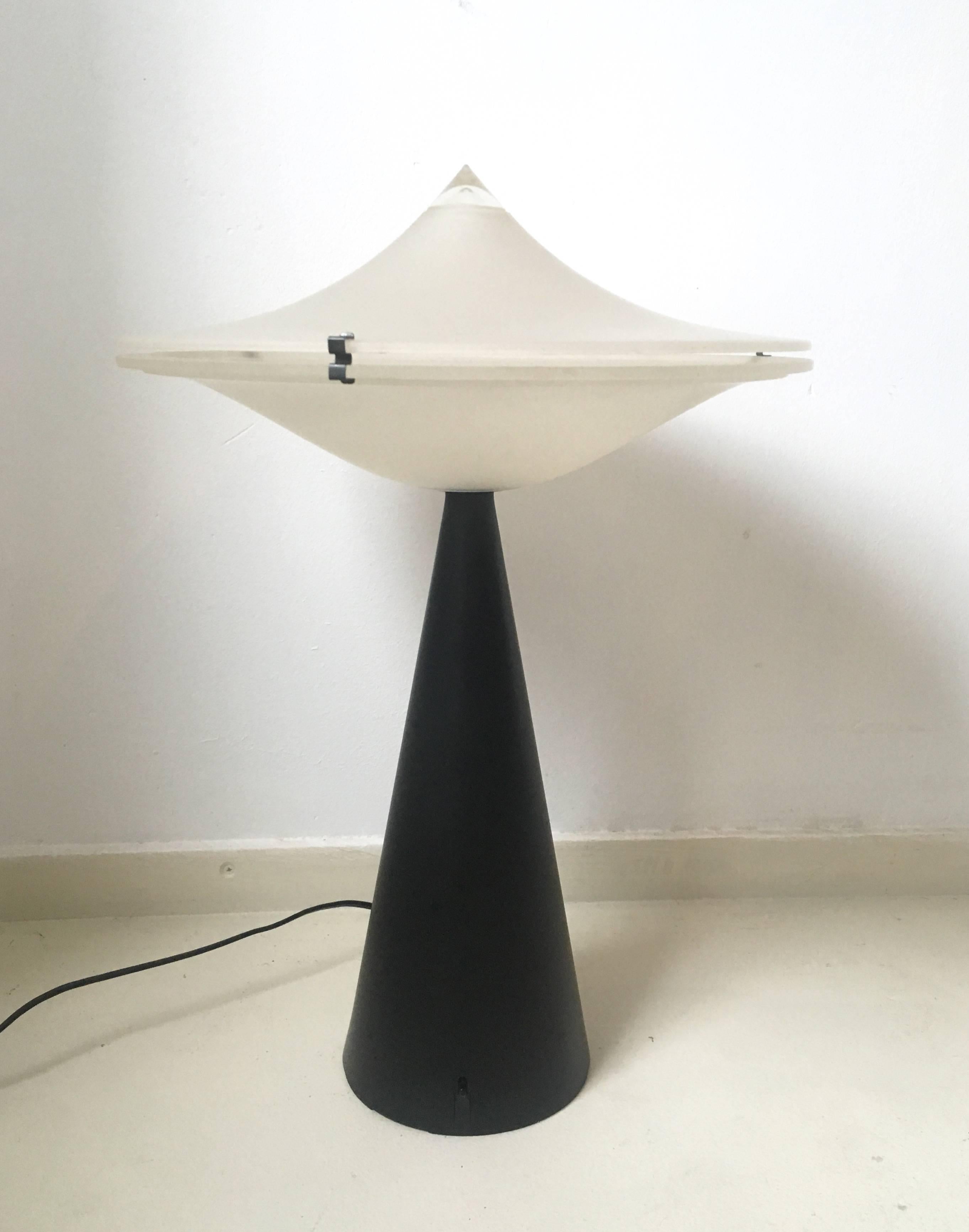 This wonderful Italian design was called 'Alien' and resembles a U.F.O. It was manufactured, circa 1975. (Space Age era).
The lamp consists of two satin glass shades attached by metal clips. A black lacquered foot is provided with a switch that