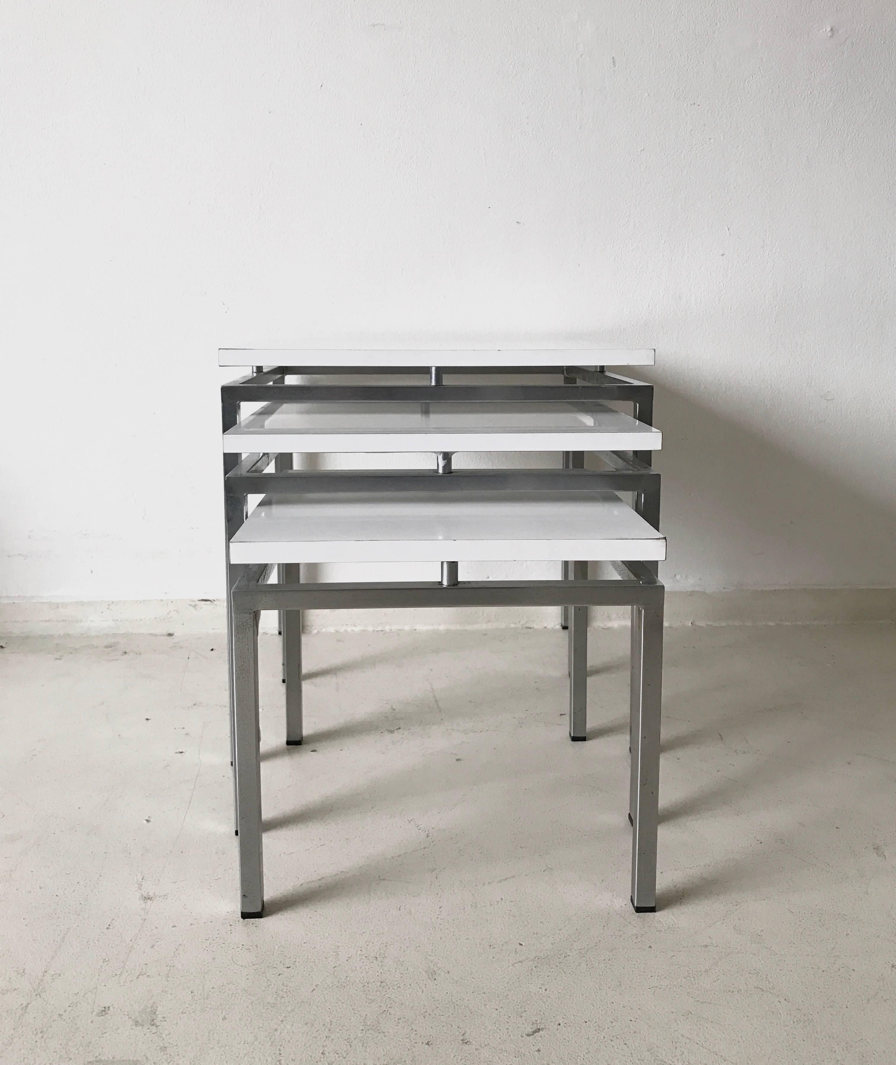 Set of three nesting tables designed by Stiemsma during the 1960s. They come with a metal base and white tops attached to it. The set remains in a good vintage condition with small signs of age and use.