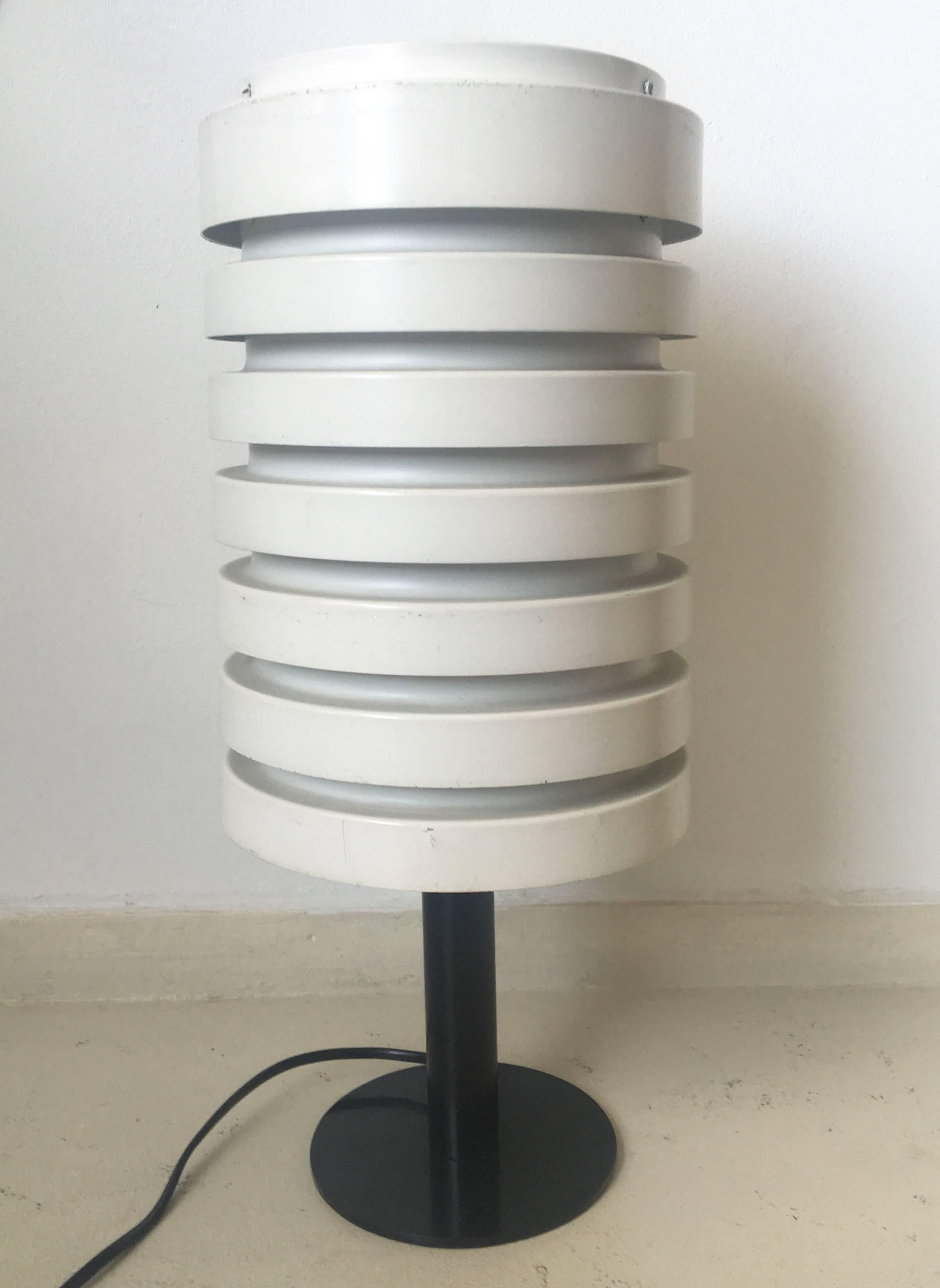 This table lamp was designed by Hans Agne Jakobsson in Sweden, circa 1960s.

It features a (off) white lacquered metal shade and a black lacquered metal base. The lamp still has its original European wiring. This wonderful item remains in a very