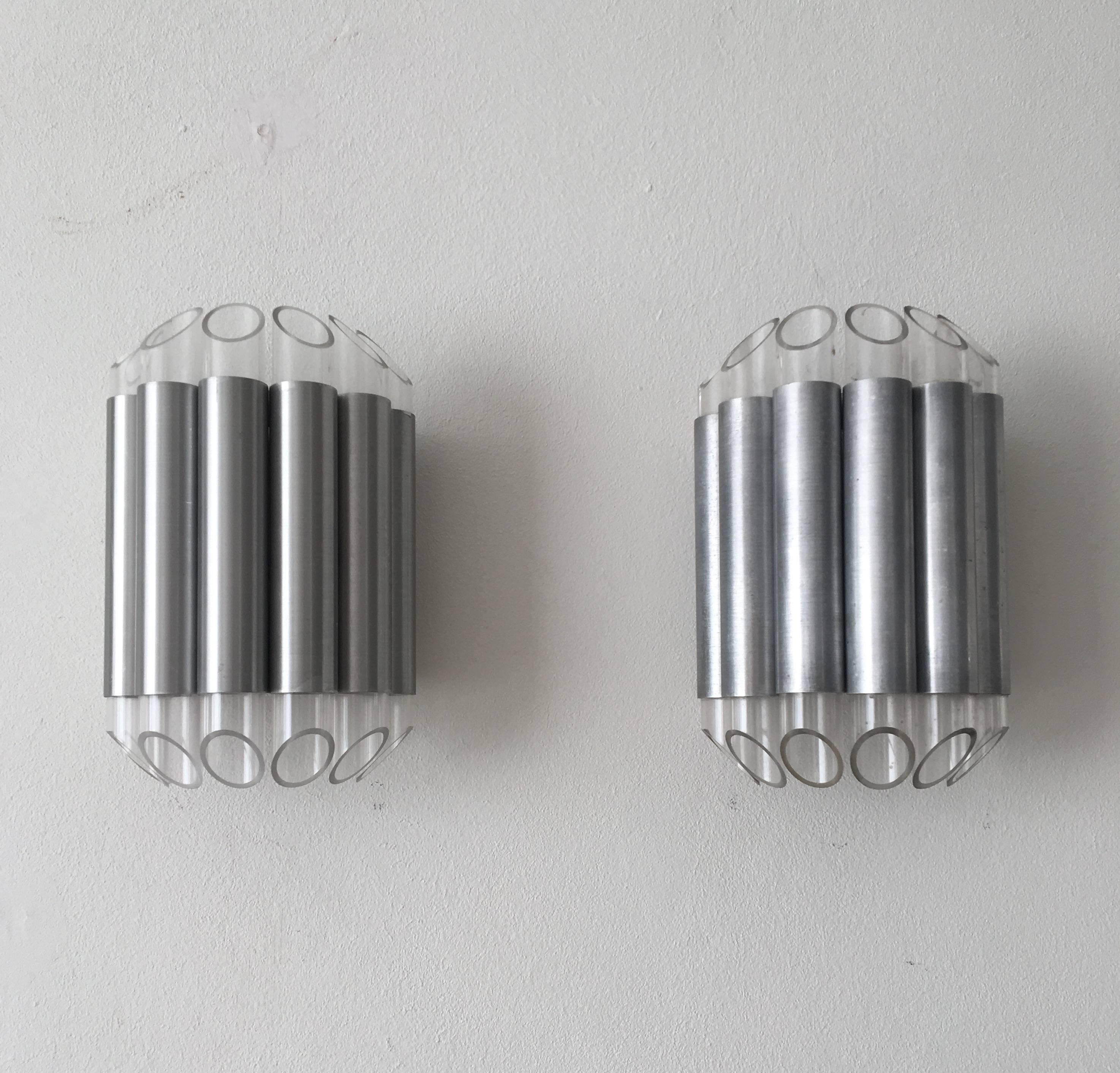 This set of two wall lamps/sconces were designed and manufactured in the Netherlands by RAAK Amsterdam. They feature an aluminium base with plexiglass ends which absorb and divide the light very nicely. 

Both lamps are in good condition but show