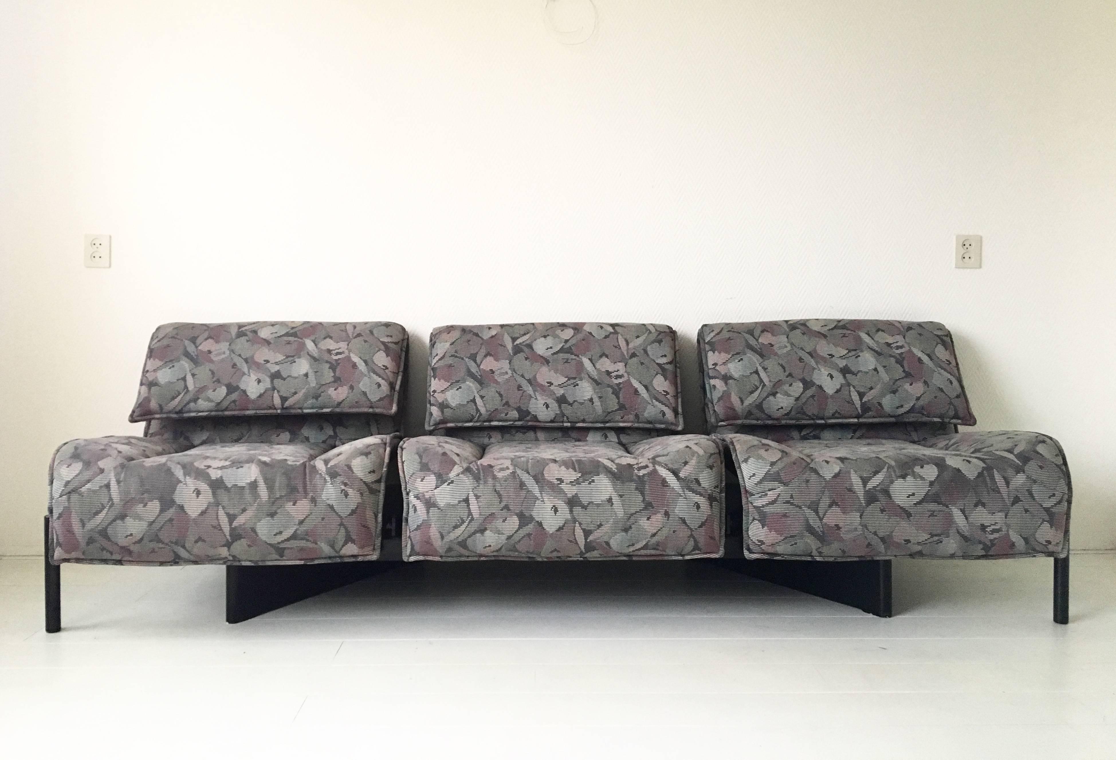 Ce canapé multicolore et réglable a été conçu par Vico Magistretti pour Cassina, vers les années 1980. Ce modèle italien, élégant et très désirable, présente des sièges recouverts de tissu et réglables en place et en hauteur, comme la version