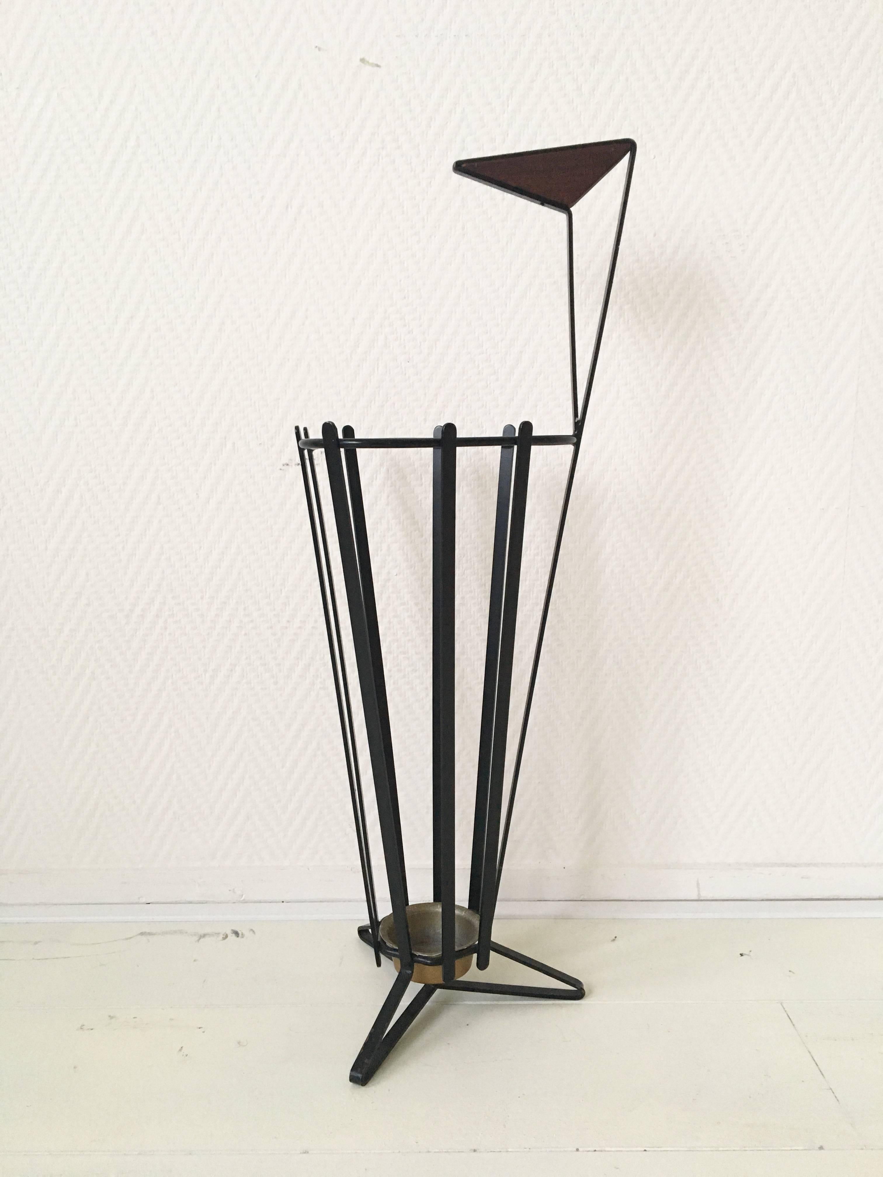 This wonderful European umbrella stand features a black metal base and a handle finished with Teak detail. It's style resembles designs of Mategot. Complete and original stand which remains in very good condition. Some normal wear consistent with
