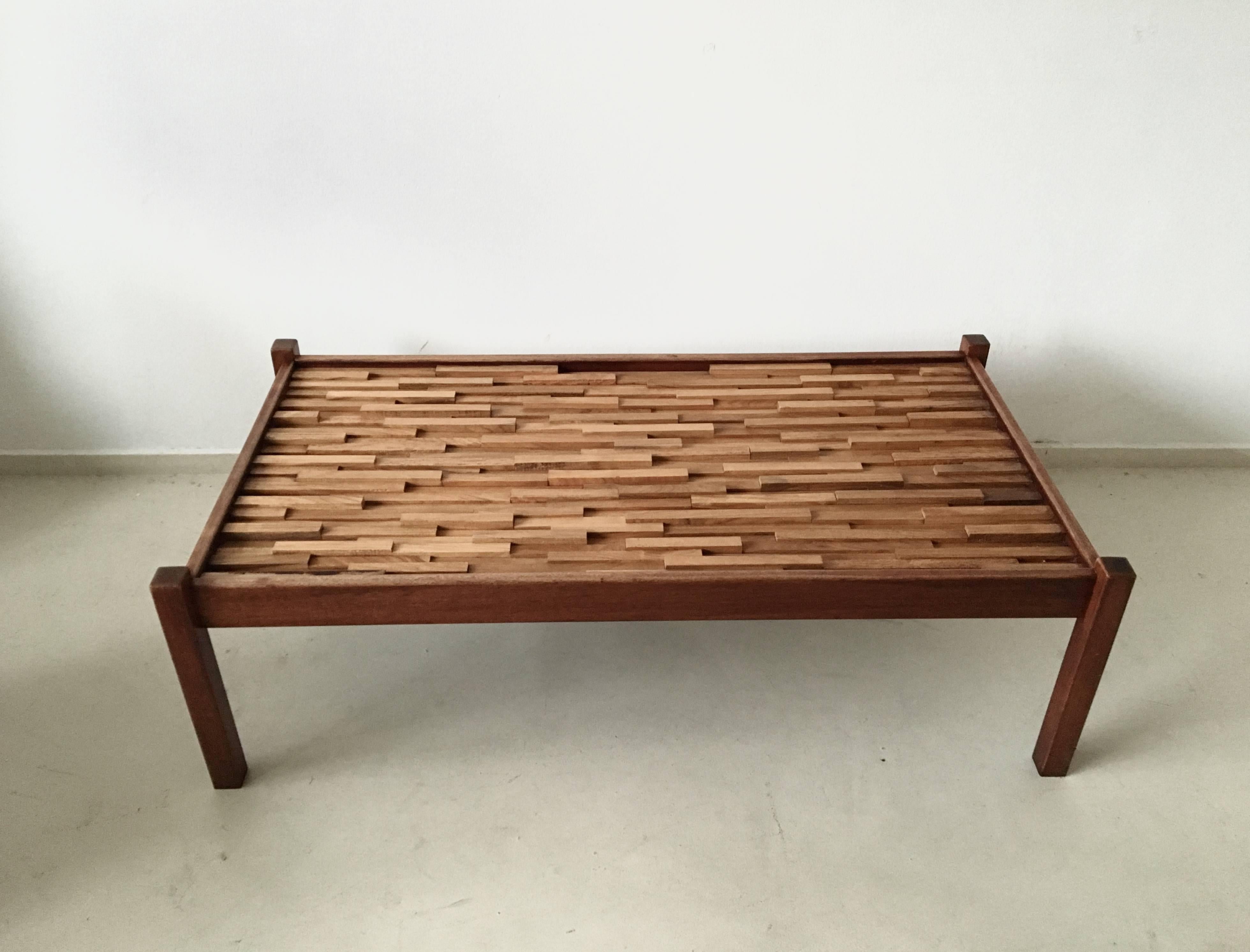 This coffee table was designed by Percival Lafer. It was manufactured in Brazil in the 1960s. The frame is made from rosewood and under the glass table top, there are also small strokes of jacaranda wood. This table is in a good vintage condition
