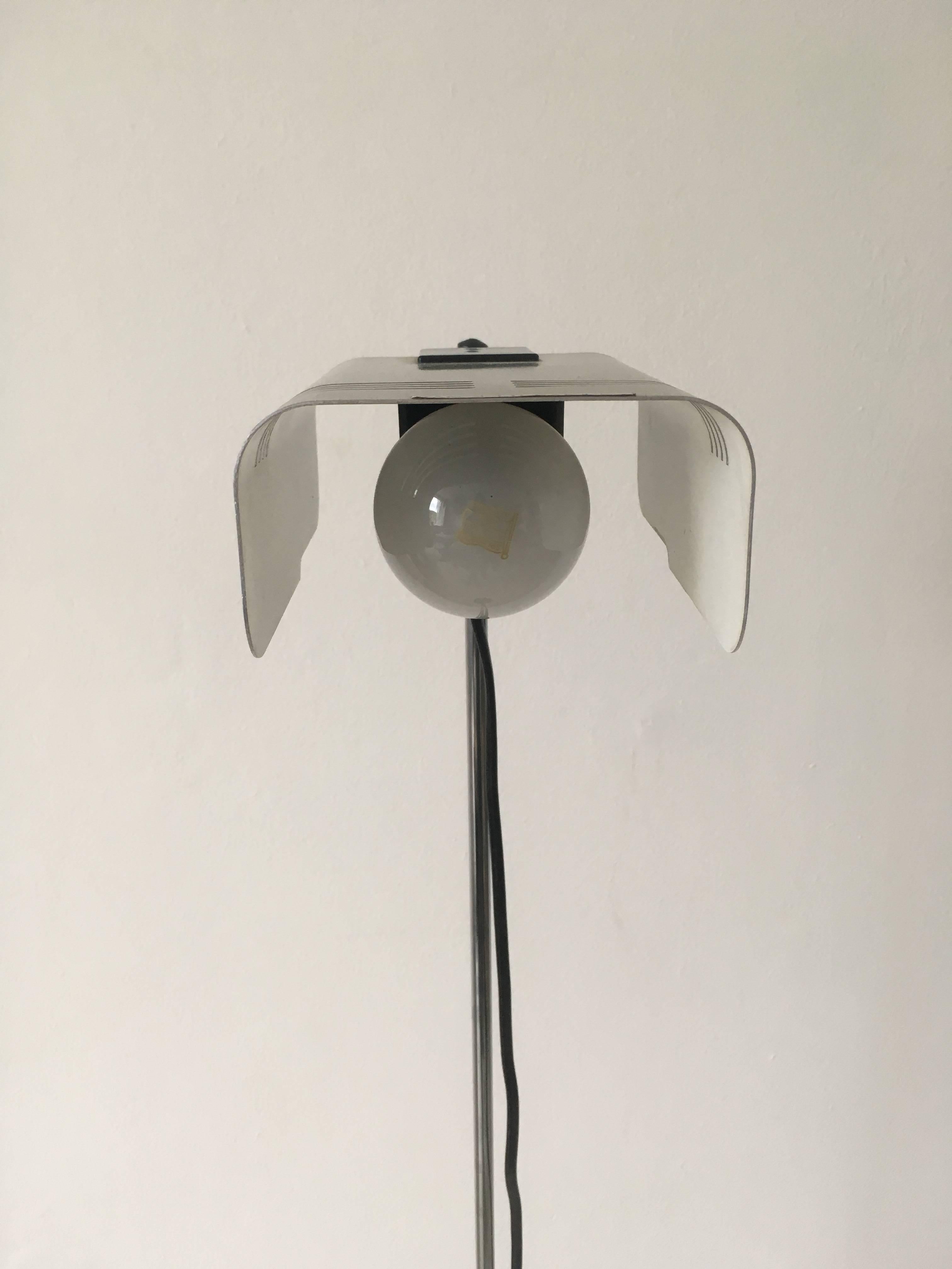This wonderful Italian design is adjustable in height. It features a chrome plated metal body and a small brushed shade. Fits well in a modern, Industrial or minimalistic designed home. The lamp is signed and is in a very good condition, with