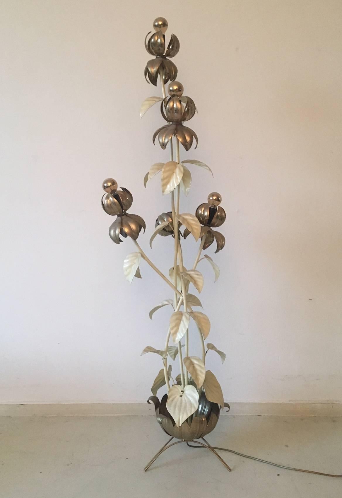 This metal work of art, features five flowers of which there are four with a light bulb. Parts of the lamp are (originally) lacquered in white, as often seen with works of Hans Kogl (maker of numerous palmtree lamps.) This piece remains in a very