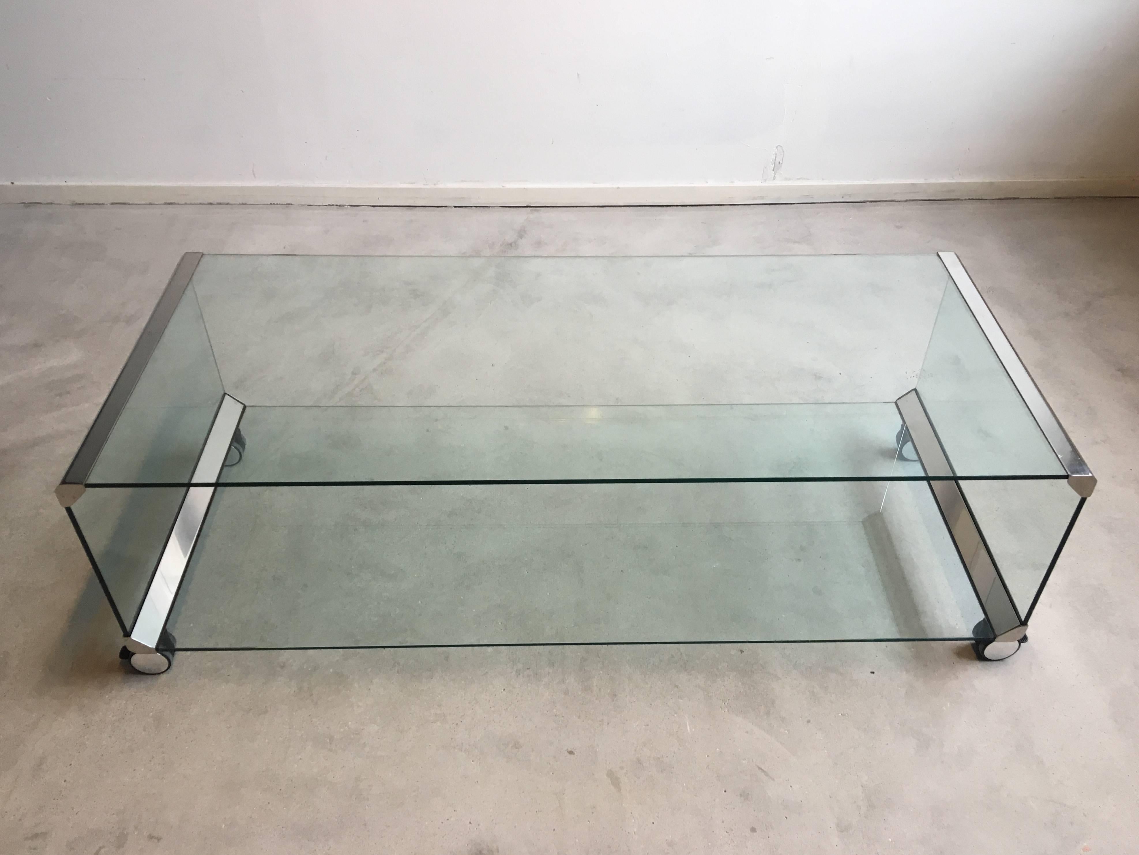 This gorgeous mobile coffee table 'George 2' was designed and manufactured in Italy in 1975. It features transparent tempered glass and stainless steel metal parts. Also it's wheels are beautifully finished. 

This coffee table or large trolley,