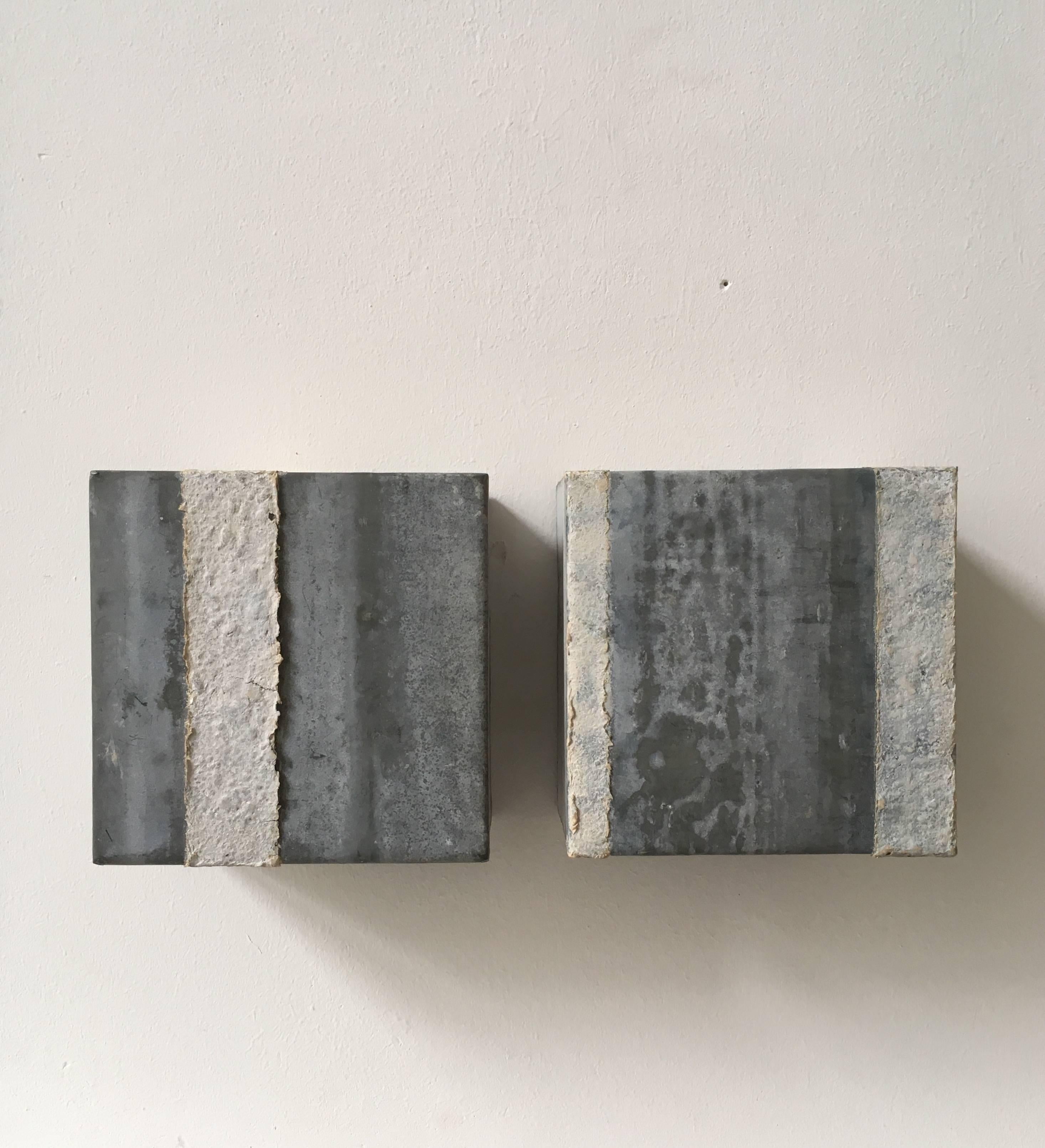 Two small wall sculptures, designed and manufactured by Dutch artist Manja Hazenberg in 2004. These cubes consist of a Zinc body with streaks of papier mâché. Excellent to give any space that minimalist touch.