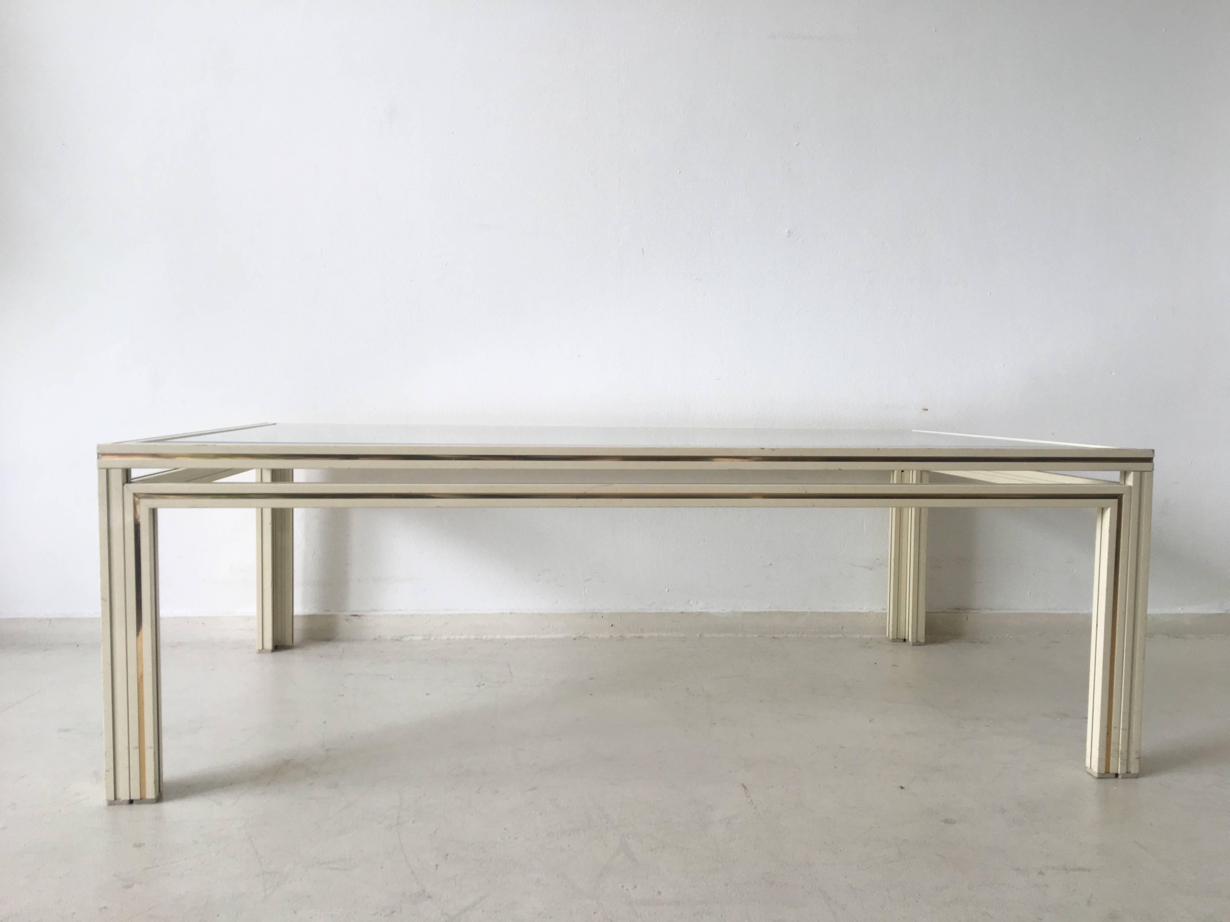 This chique French coffee table consists a bevelled glass top and aluminium base with off-white and gold colored finish. The table remains in good condition with wear consisting with age a use.