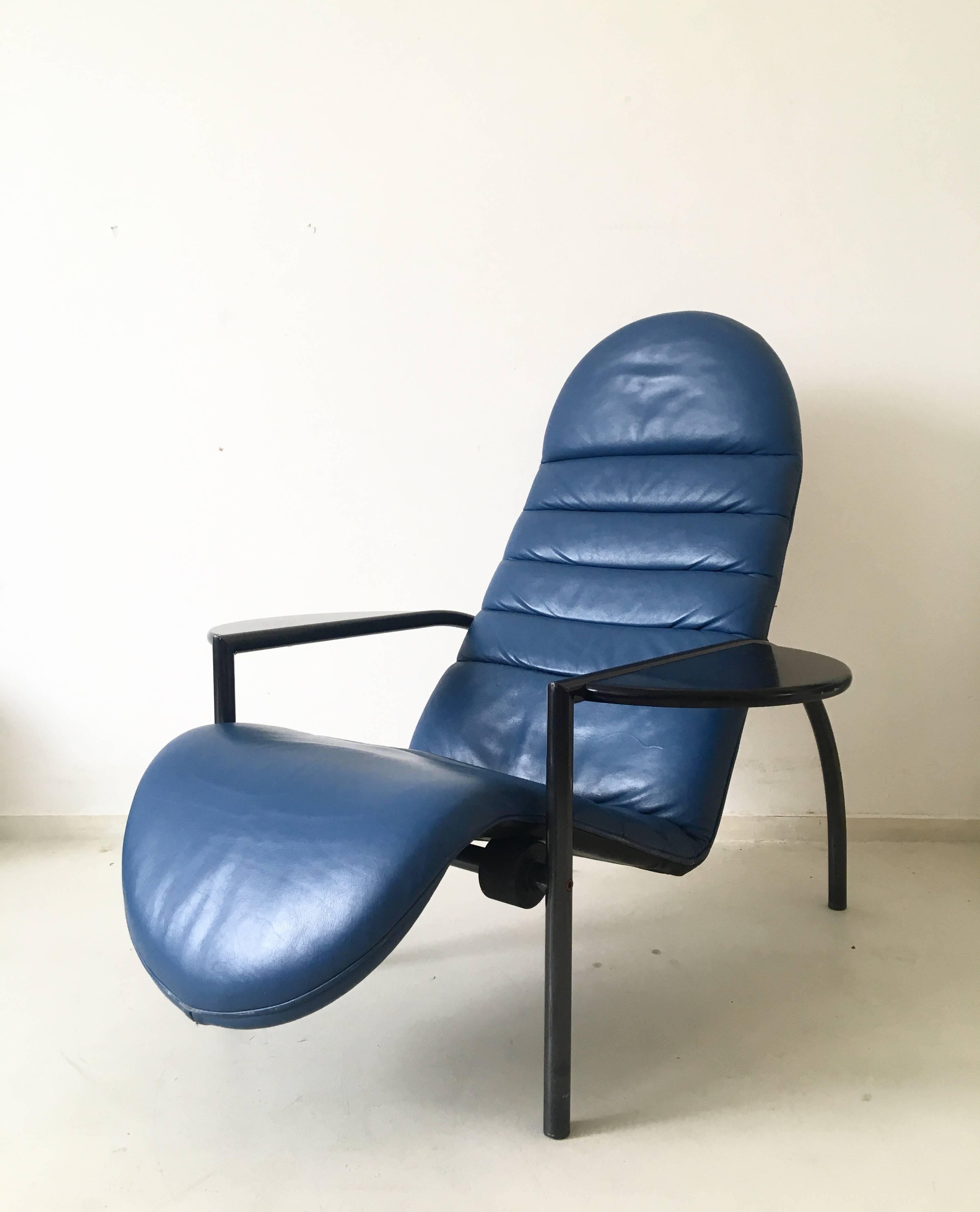 Extremely hard to find, is this so called 'Noe' chair by Moroso. (Confirmed by the Moroso team).

The chair features a metal frame with a blue leather seat and armrests in wood that can function easily as tables.

Thanks to a simple, yet functional