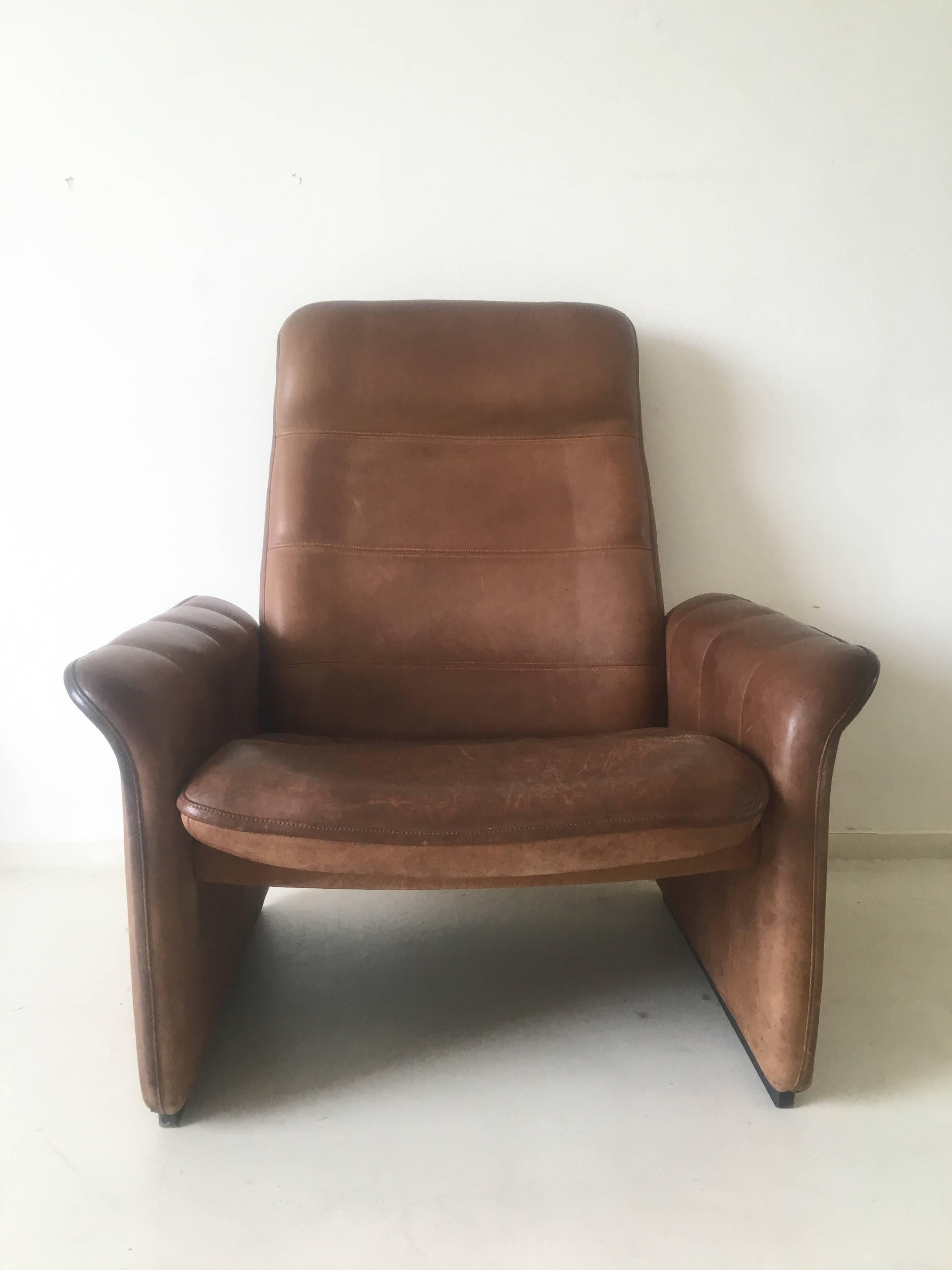This wonderful lounge chair was designed and manufactured in Switzerland, circa the 1960s. It features a thick Buffalo leather body on a heavy base of wood. However the leather is good condition, it does show some signs of age and use. No rips or