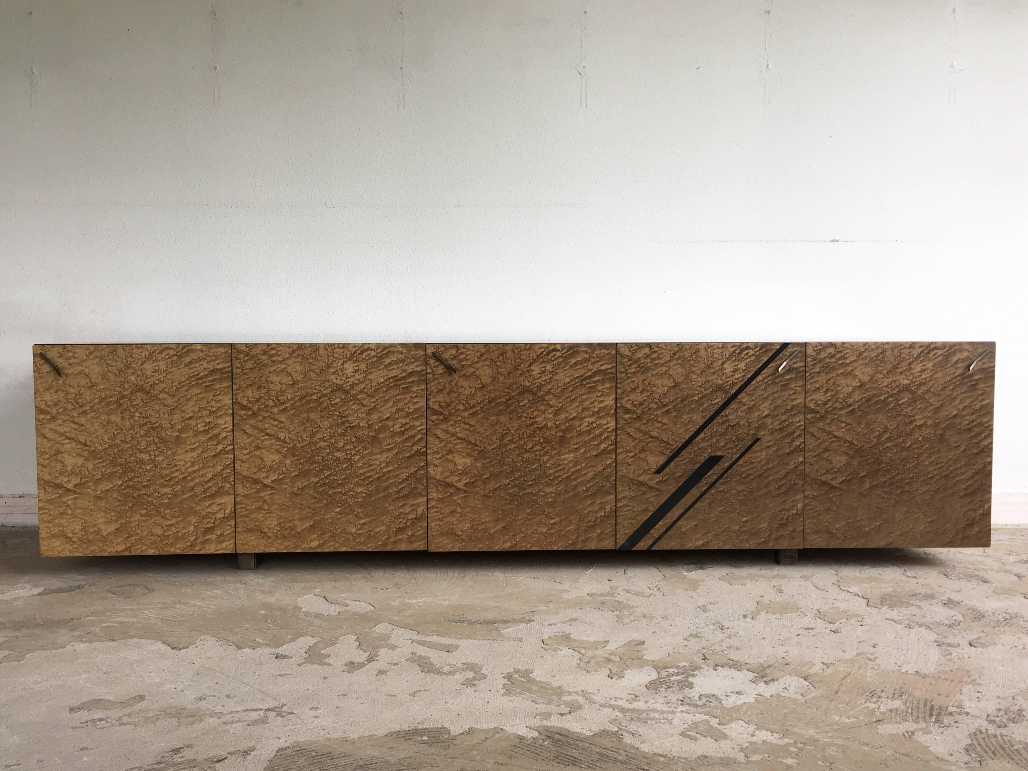 Absolut beeindruckendes italienisches Sideboard, entworfen von Giovanni Offredi für Saporiti.
Er hat einen mit Vogelaugenahorn furnierten Holzsockel und elegante Griffe aus Messing. Im Inneren verfügt dieses Möbelstück über Regale und zwei