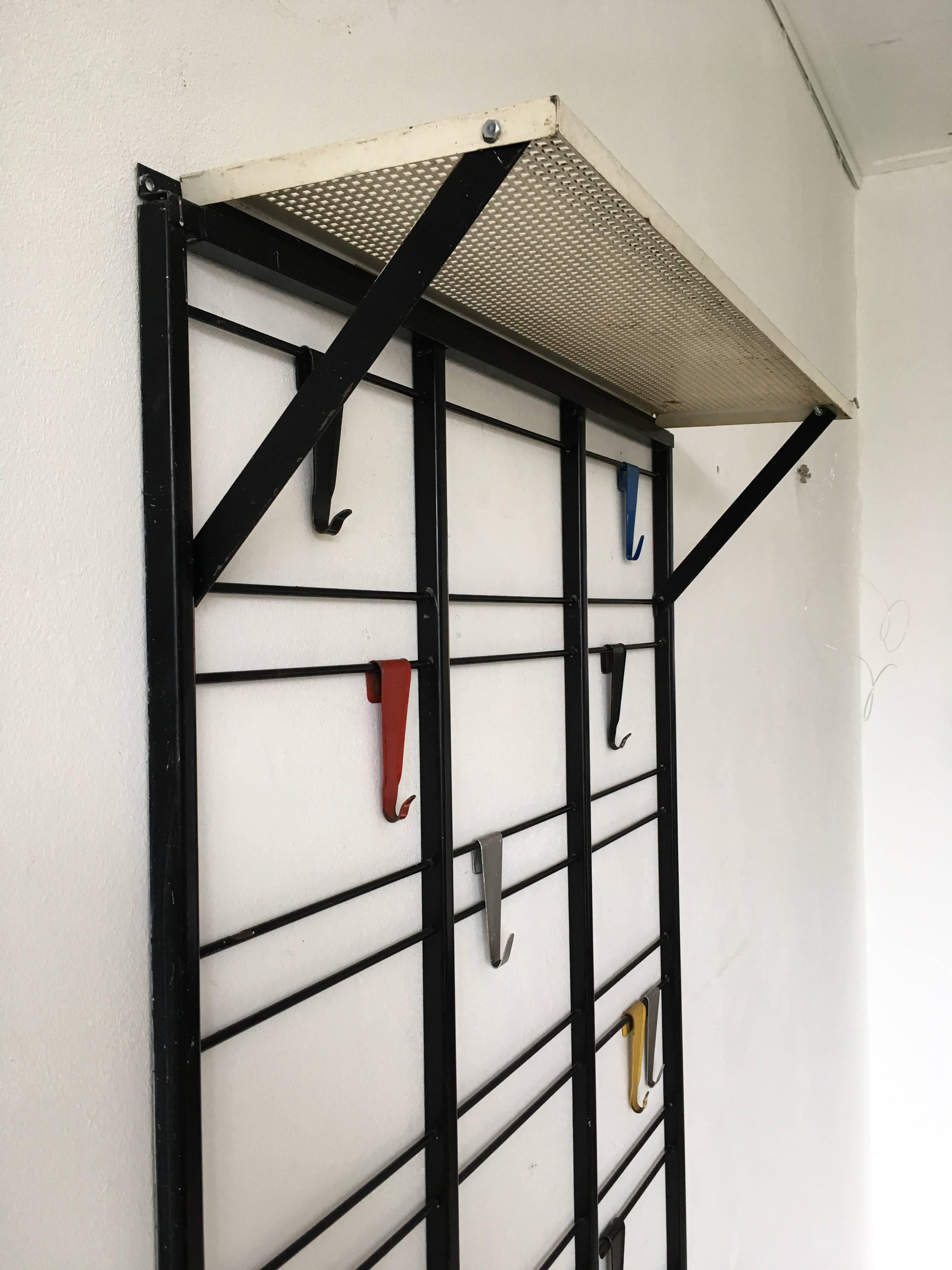 Gorgeous Industrial piece from The Netherlands called 'Toonladder'. Designed by Coen de Vries for Pilastro circa 1950s in The Netherlands. This rack comes with a hat rack on top and 18 hooks. This Dutch design item remains in good condition with