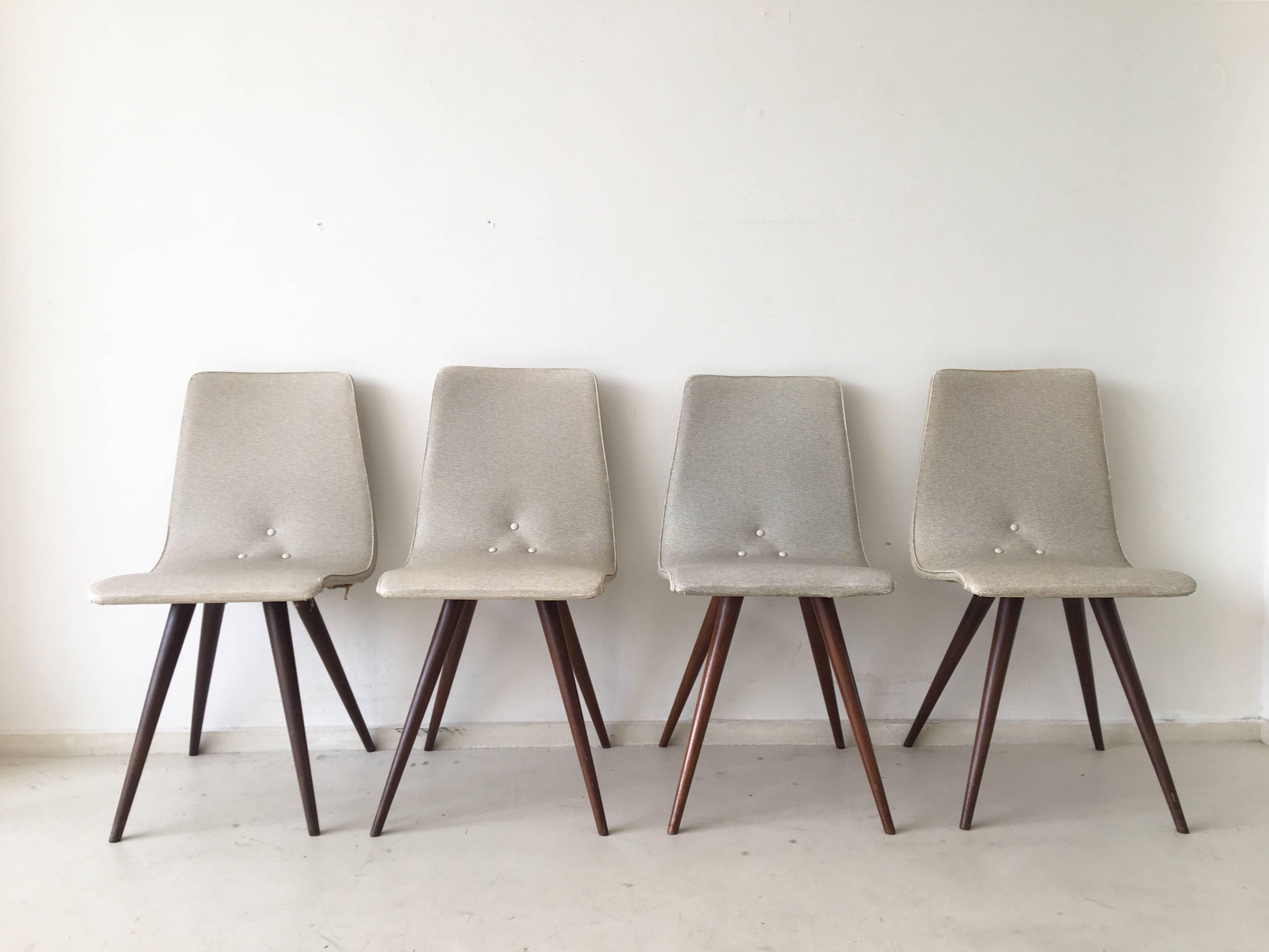 Elegant set of four dining chairs featuring each four tapered teak legs and a comfortable flexible seating which still has its original upholstery. However the leatherette is in good condition, it might show slight discoloration and other wear over