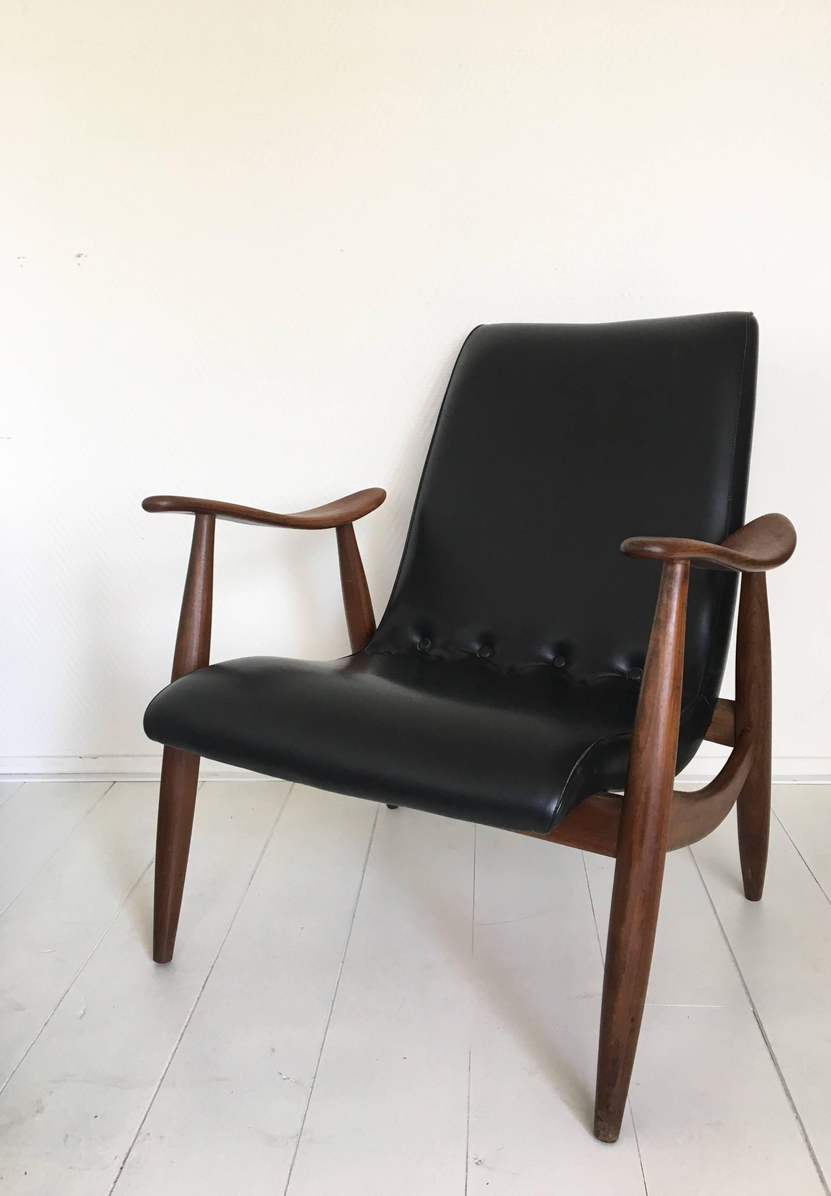 This gorgeous Dutch design features a teak frame with a black Leatherette upholstery. The chair remains in wonderful condition with some signs of age and use (scratches to the Leatherette and some light wear to it's teak frame).
 