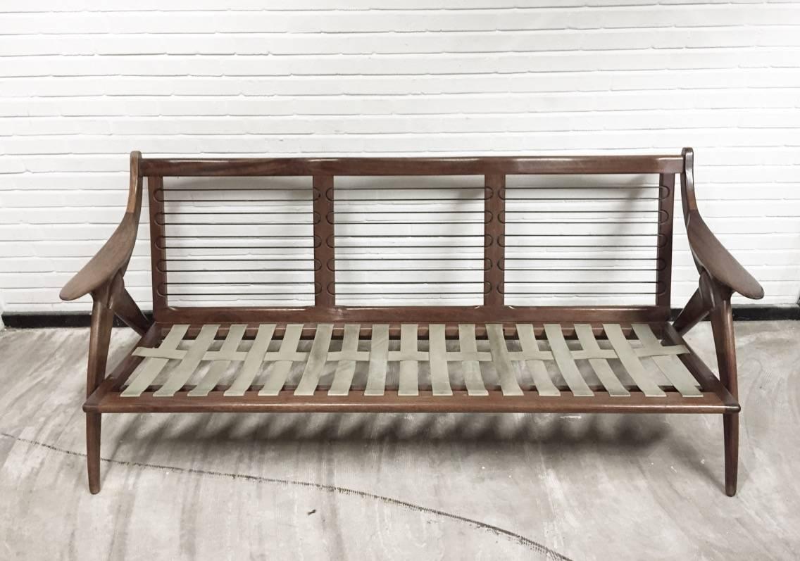 This midcentury sofa was manufactured by De Ster Gelderland in The Netherlands. It has an organic-shaped massive wooden frame and original off-white upholstery which best can be renewed. Also it's foam and singles are best to be replaced.
 