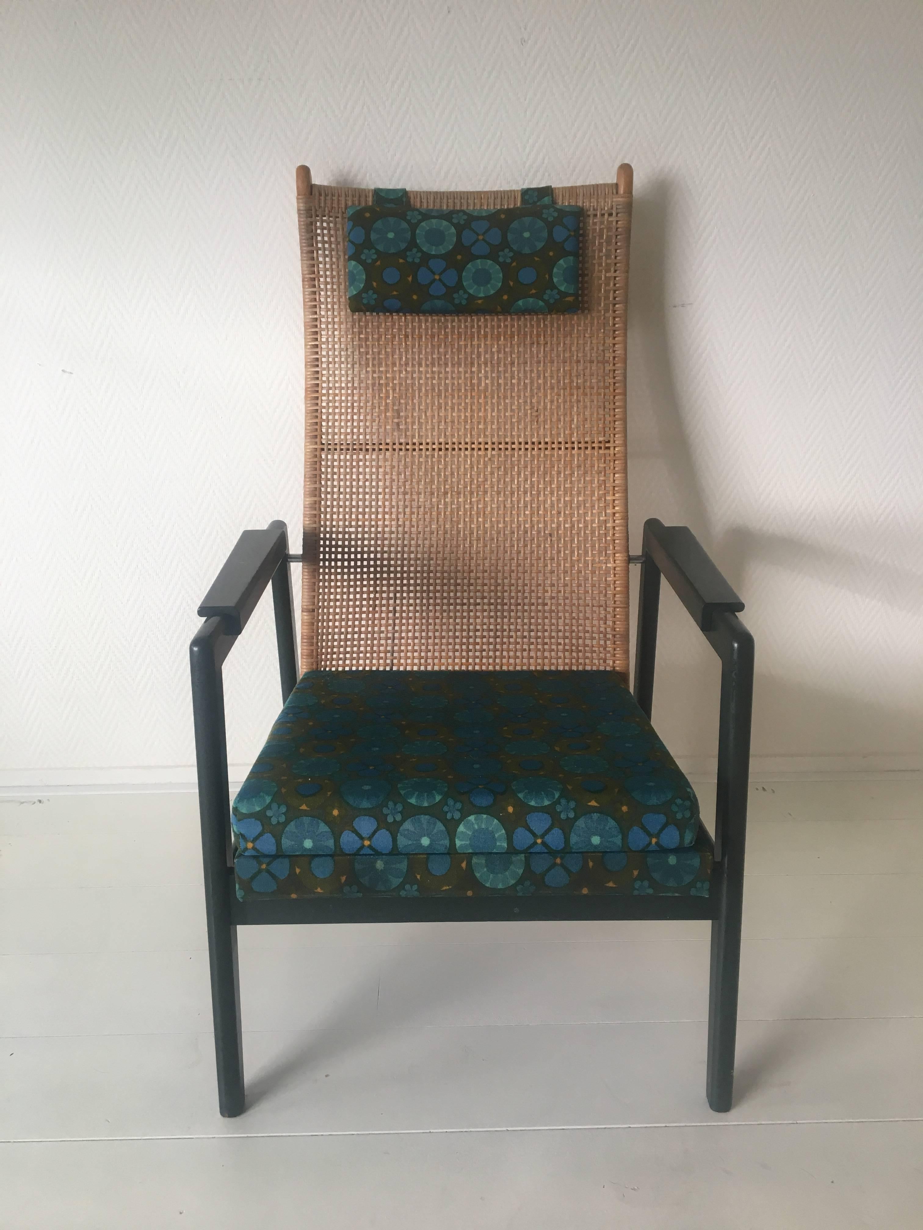 This lounge chair was designed by P. Muntendam for Jonkers in the 1950s-1960s. It features a dark green original lacquered wooden frame and a 'flower power'/bohemian style printed fabric from the same time period. The back of the chair is made from