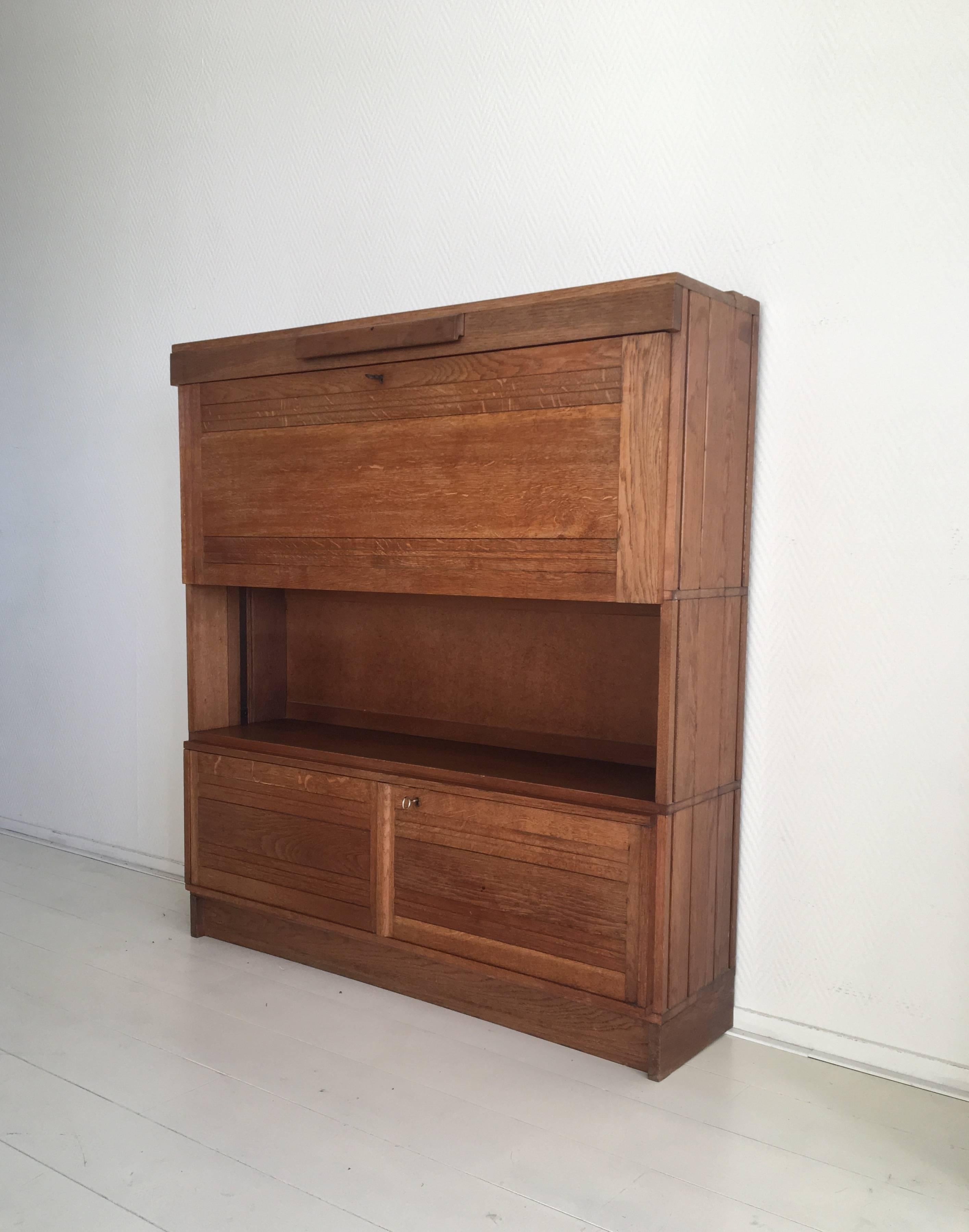 This very modest but sophisticated piece was made from Oak and features a drop down front with the original key. Just above this front, a concealed lamp with a smoked lucite top, can be extracted from the desk. Wiring of the lamp has been replaced.