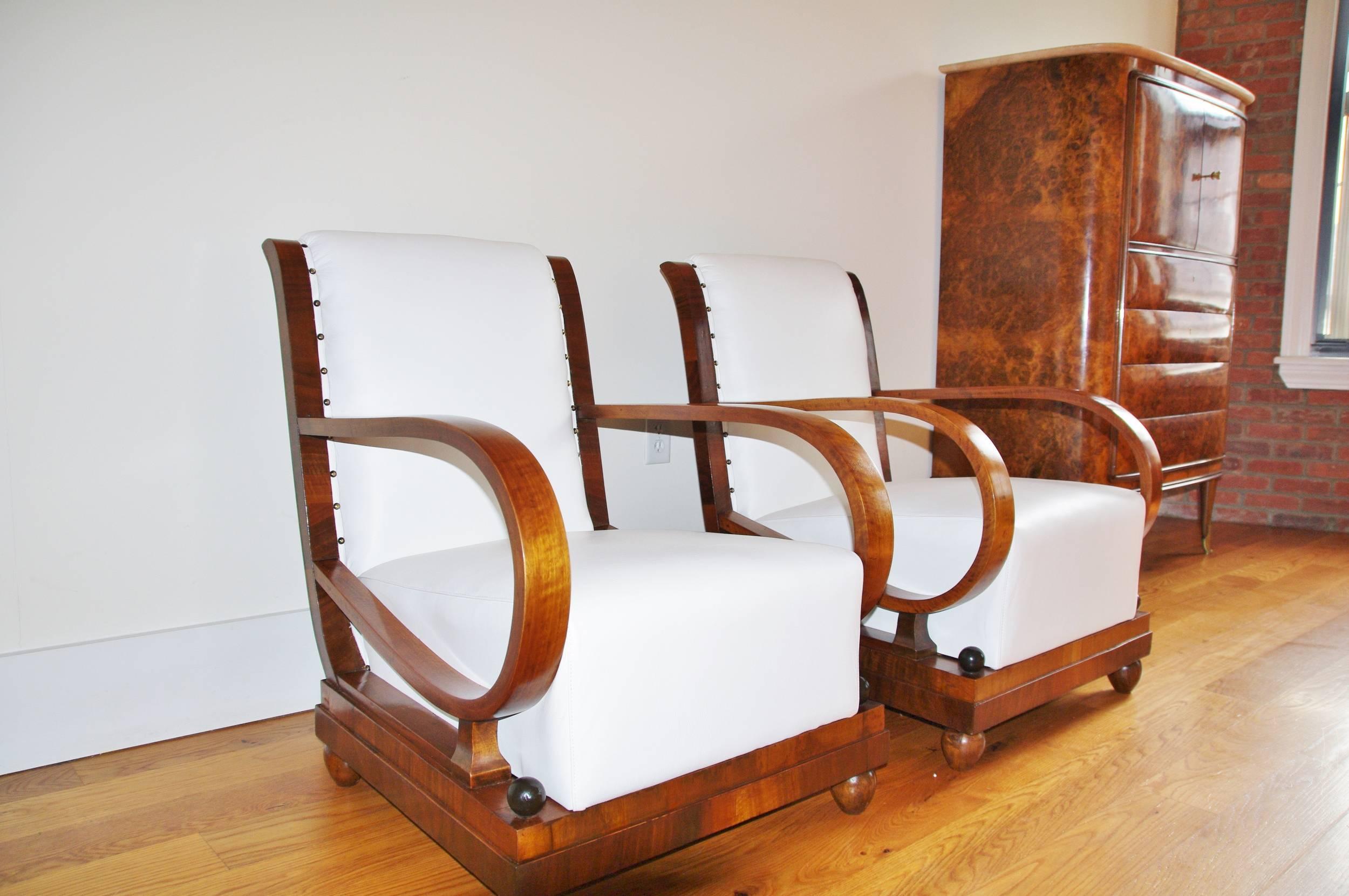 Beautiful pair of Art Deco Italian Lounge Chairs manufactured by Ditta Marzorati di Seveso (MB), circa 1940. The Art Deco details of these beautiful  lounge chairs  are all there: the rounded wooden armrests, the massive geometrical shaped base and