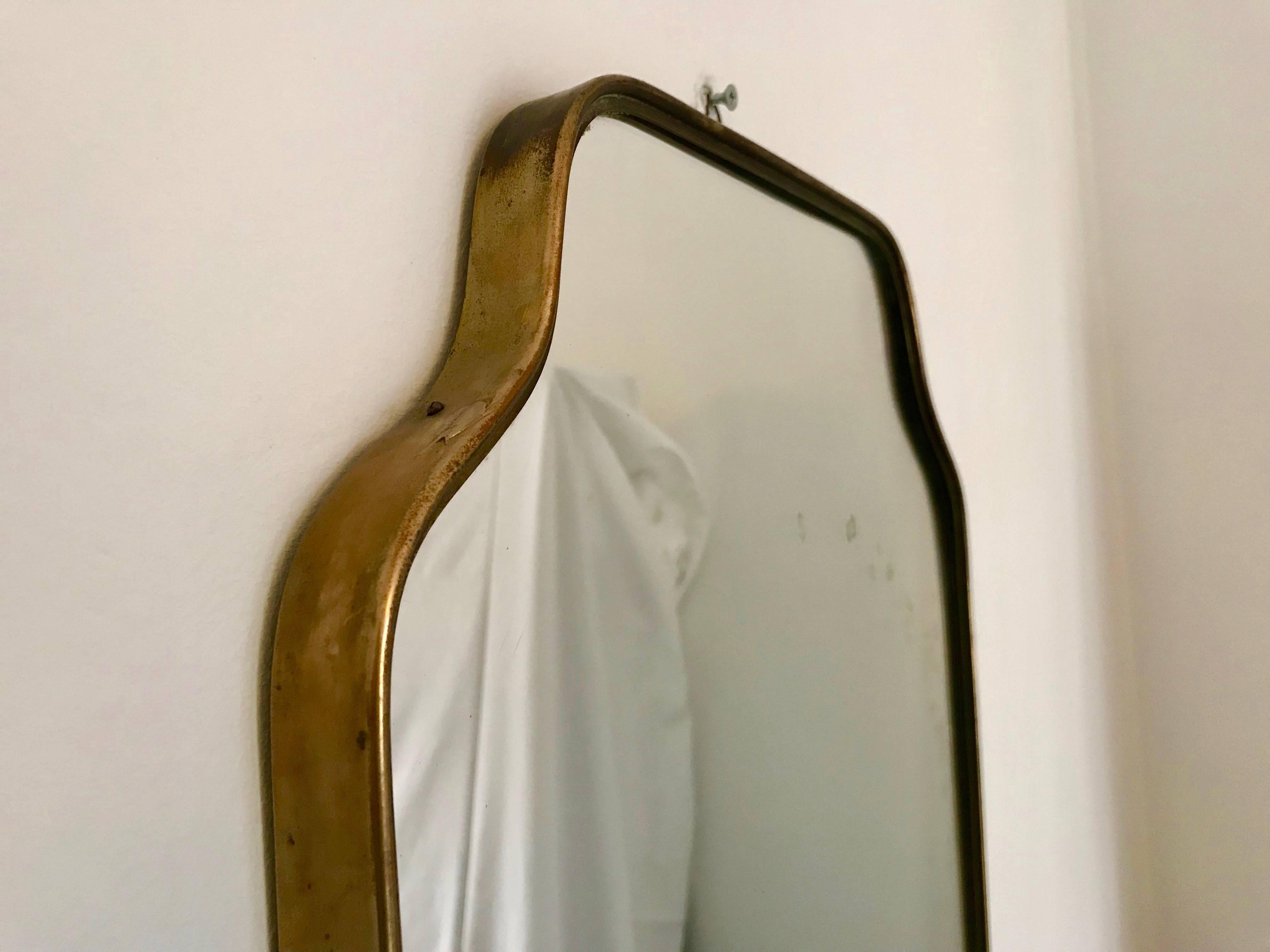 Authentic Italian Brass Mirror from the Mid Century period, original condition. The mirror presents some signs which is completely normal due to age and a direct testimony of its intact authenticity. Approx size 69h x 41 cm