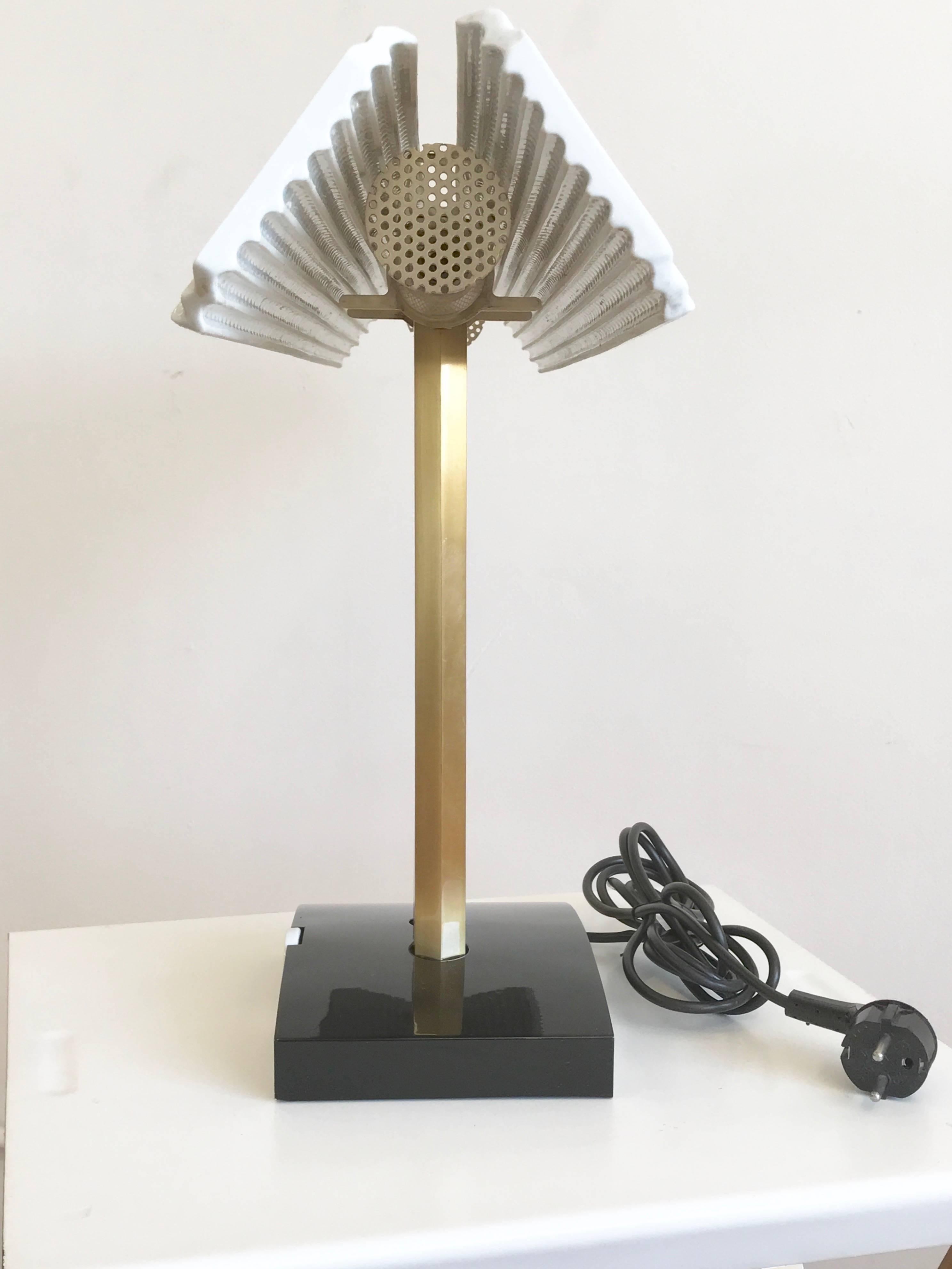 Rare Capalonga table lamp, designed by Afra & Tobia Scarpa, manufactured by Flos in 1982 . Polished brass, enameled metal, porcelain bisque reflector. Dimmer light intensity. 

Size: 15.7" H, 27.5" W, 5.9" D 

Literature: G.